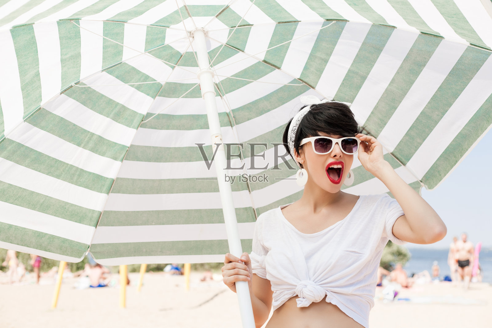 在阳光沙滩上戴眼镜的女人照片摄影图片