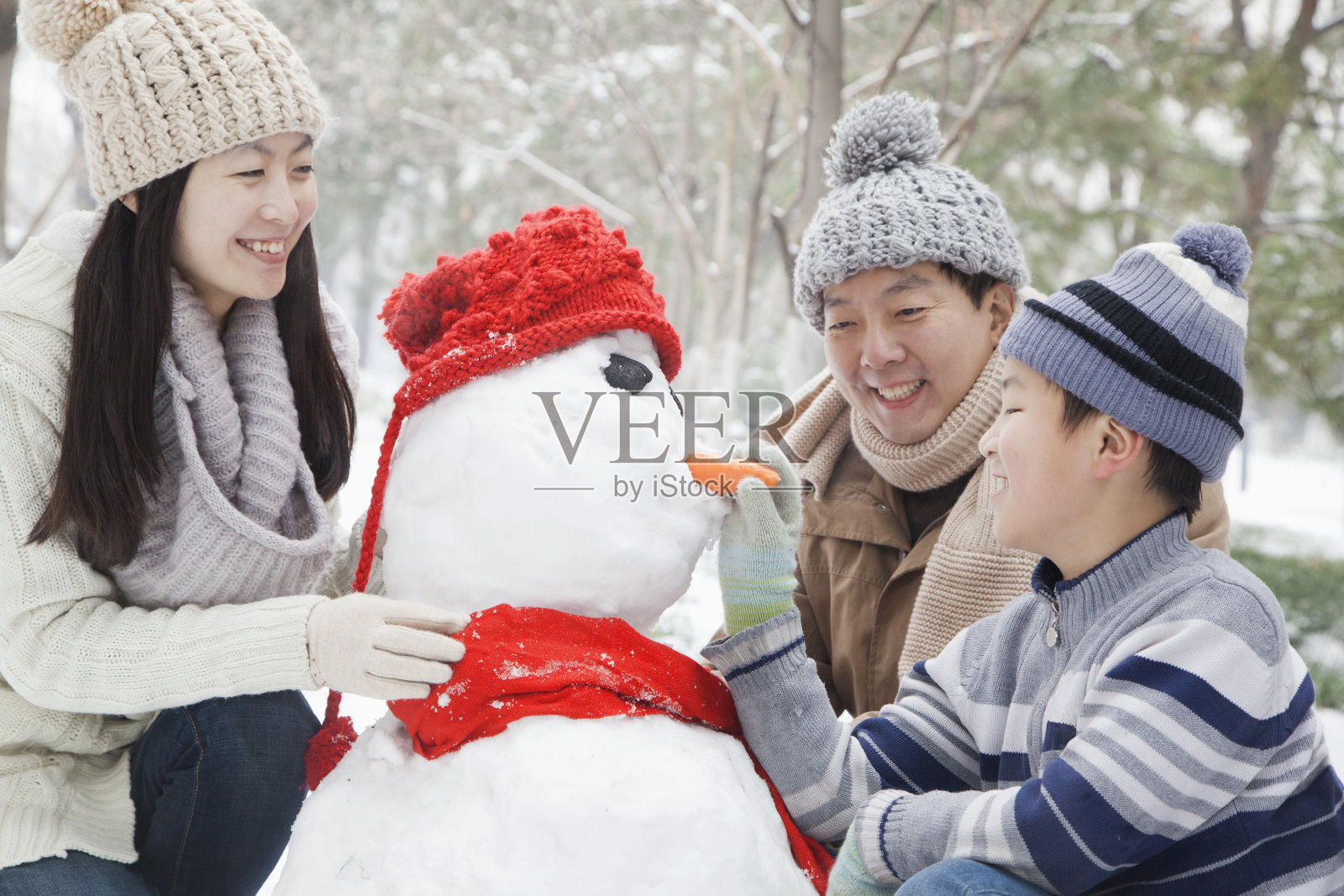 一家人在冬天堆雪人照片摄影图片