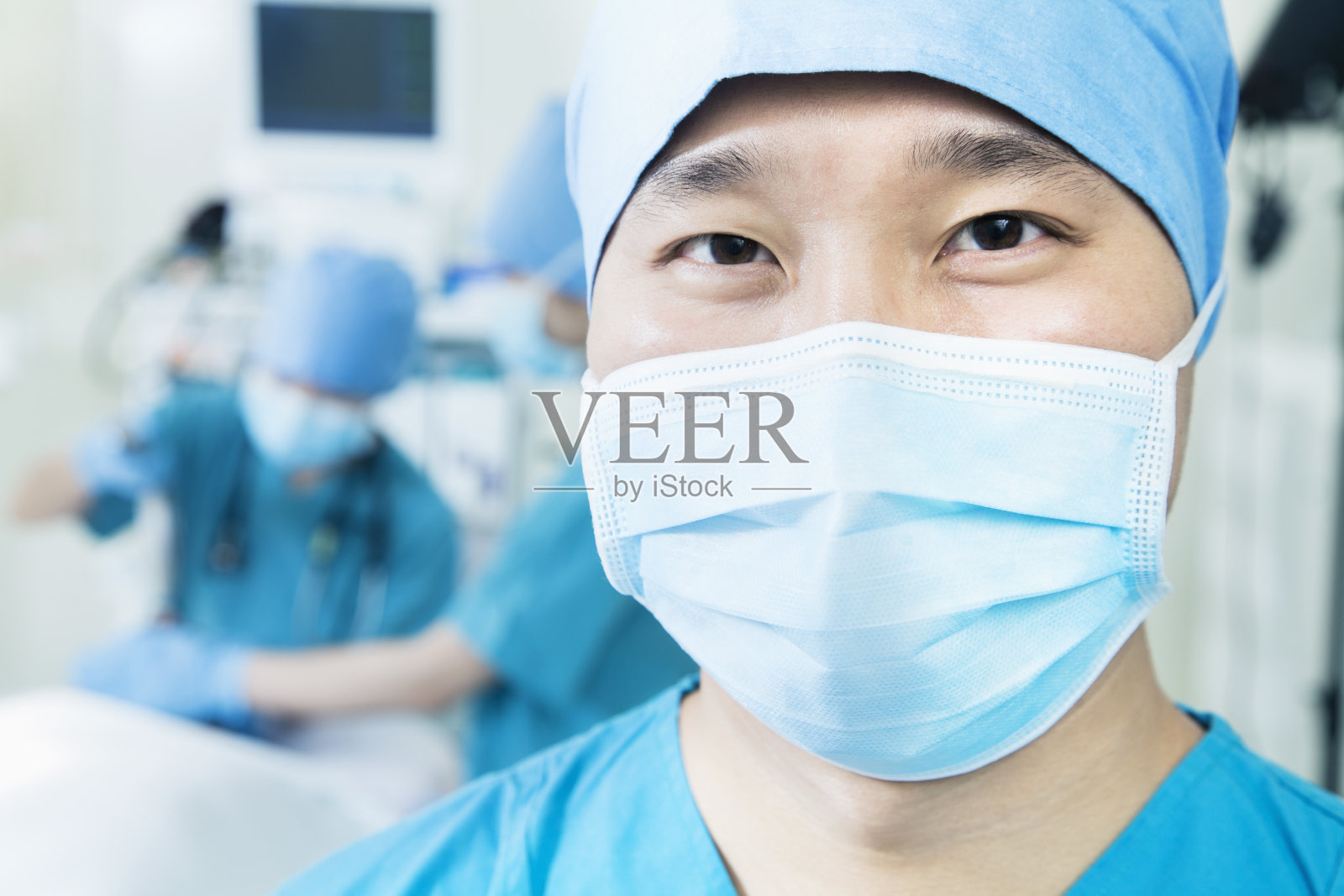 外科医生戴着手术口罩在手术室里，特写照片摄影图片