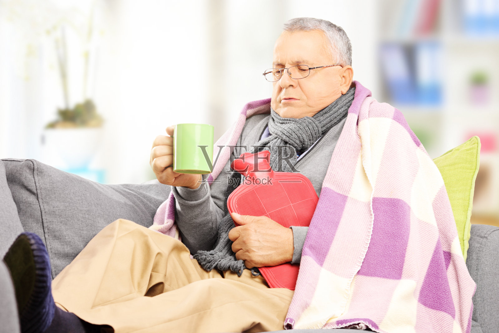 一位患流感的老人正在暖和地喝茶照片摄影图片