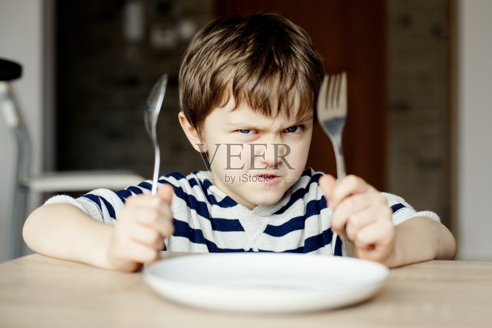 愤怒的小男孩等着吃晚饭照片摄影图片