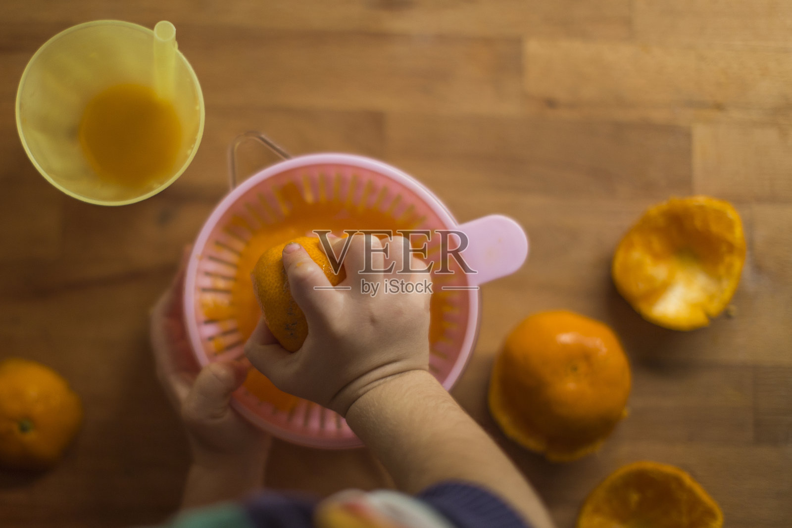 小孩正在准备新鲜的自制橙汁照片摄影图片