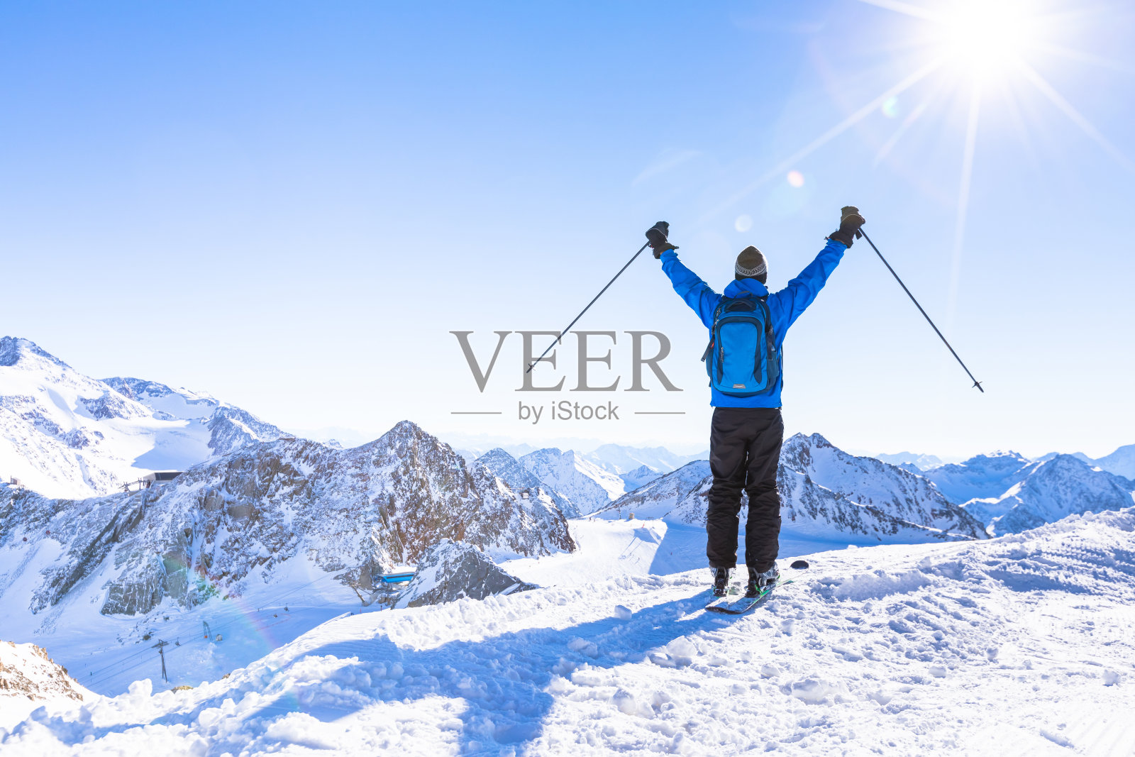 一个快乐的滑雪者举起双手的后视图照片摄影图片