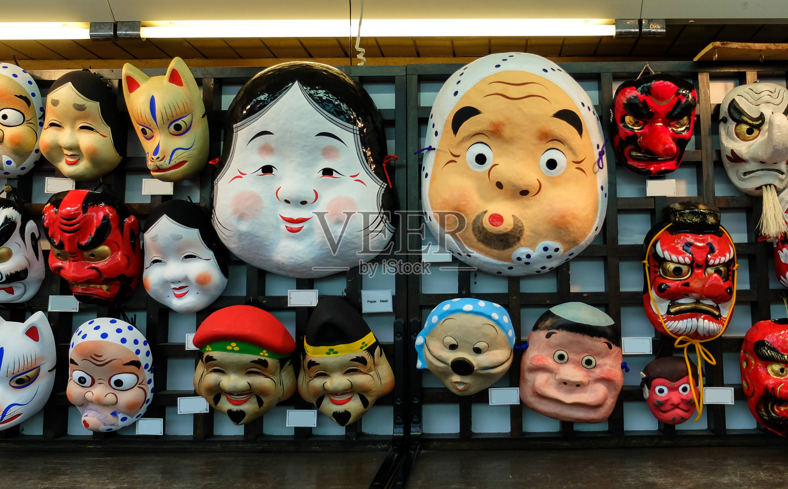 日本各种创意古代纸面具，用于传统活动挂在木墙上出售照片摄影图片