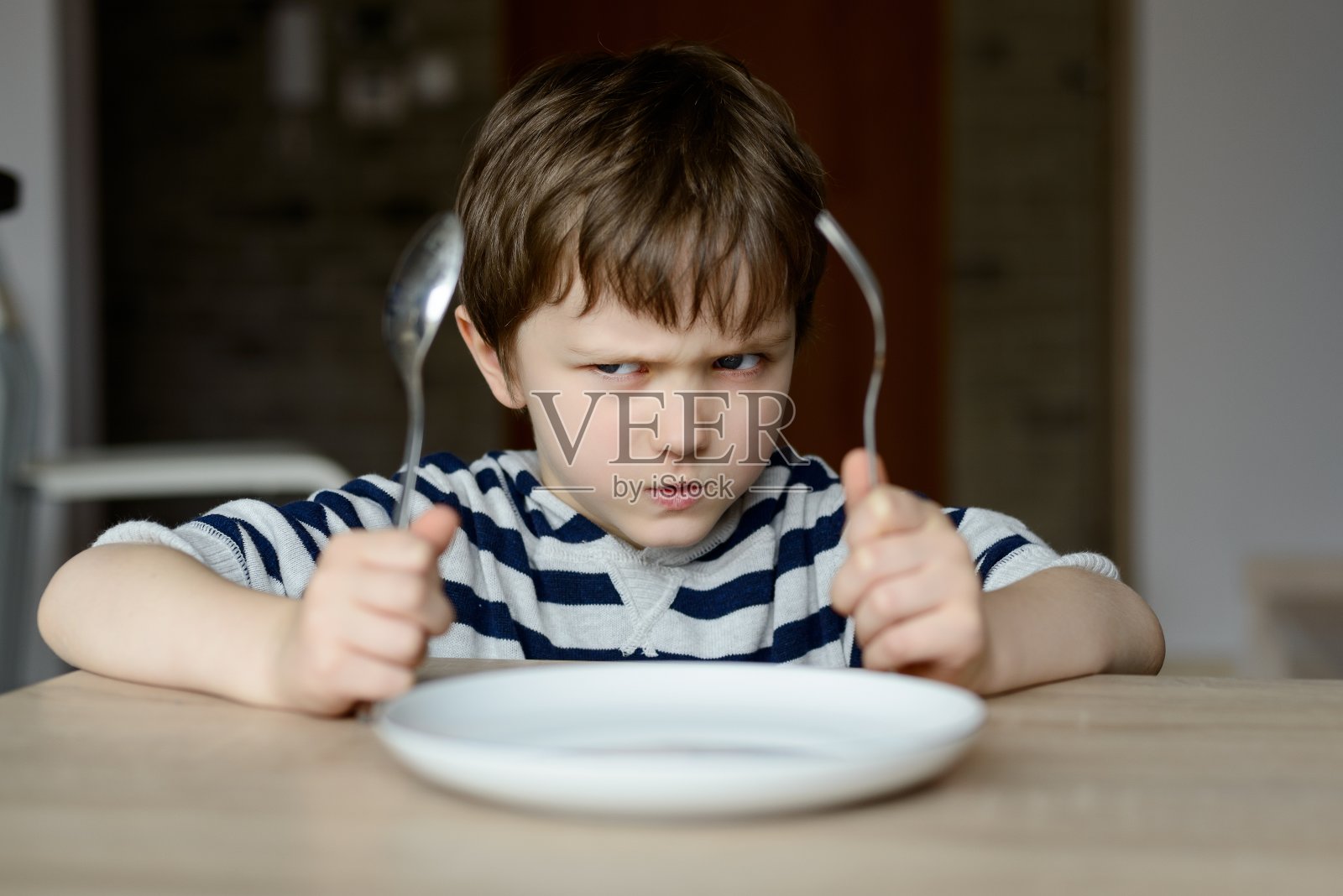 沮丧的小男孩等着吃晚饭照片摄影图片
