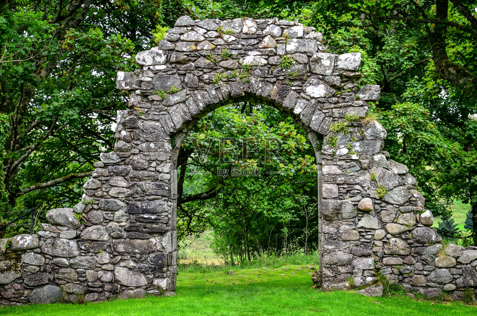 古老的石头入口墙在绿色花园照片摄影图片