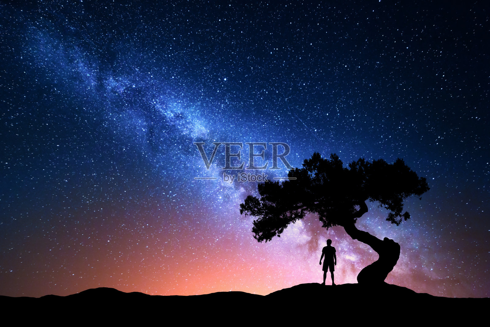 银河，树和孤独的人的剪影。晚上的风景照片摄影图片