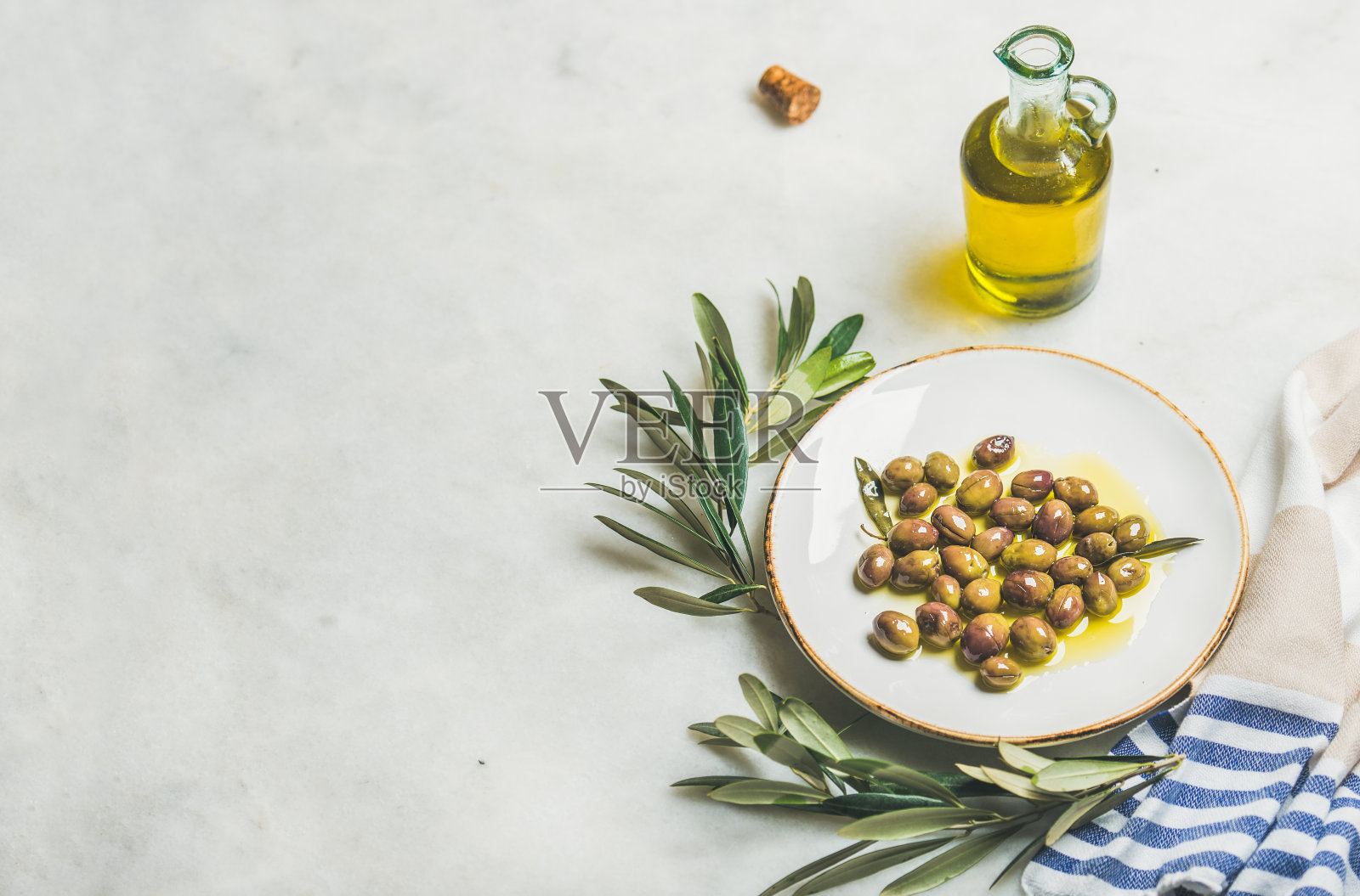 腌制地中海绿色橄榄，橄榄枝和橄榄油照片摄影图片