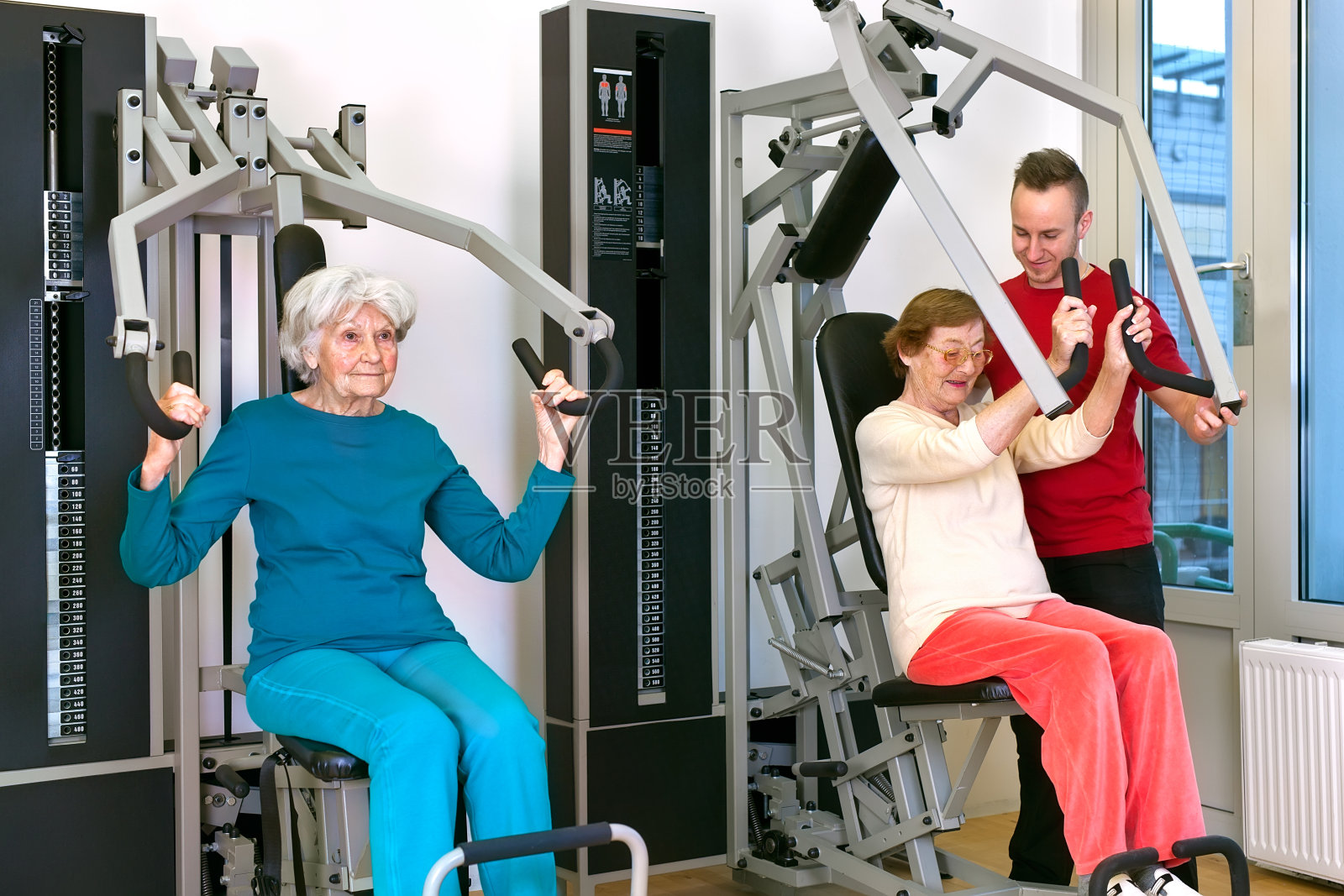 和教练一起在健身房锻炼的老妇人。照片摄影图片