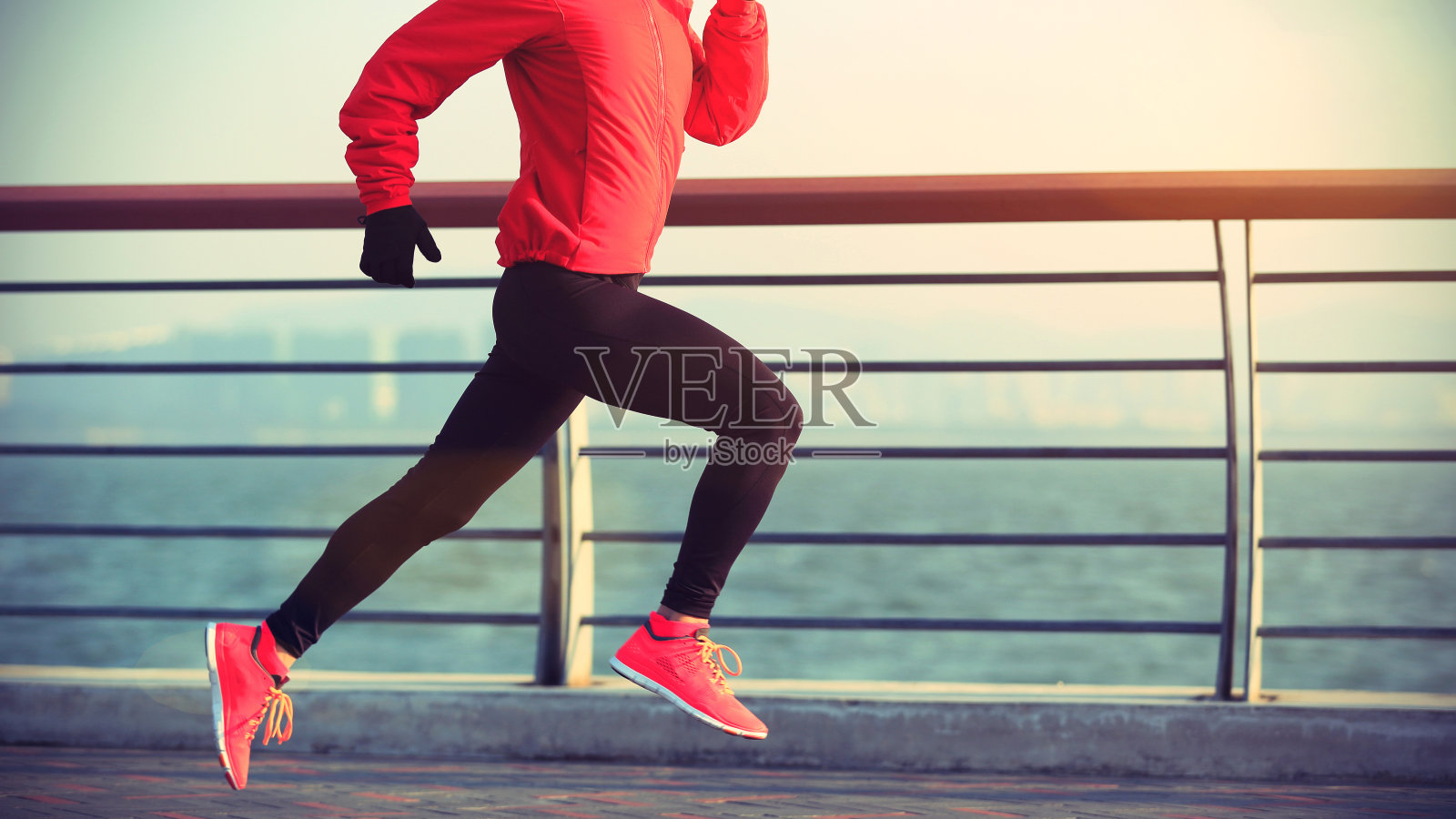 年轻的健身女运动员在海边跑步照片摄影图片