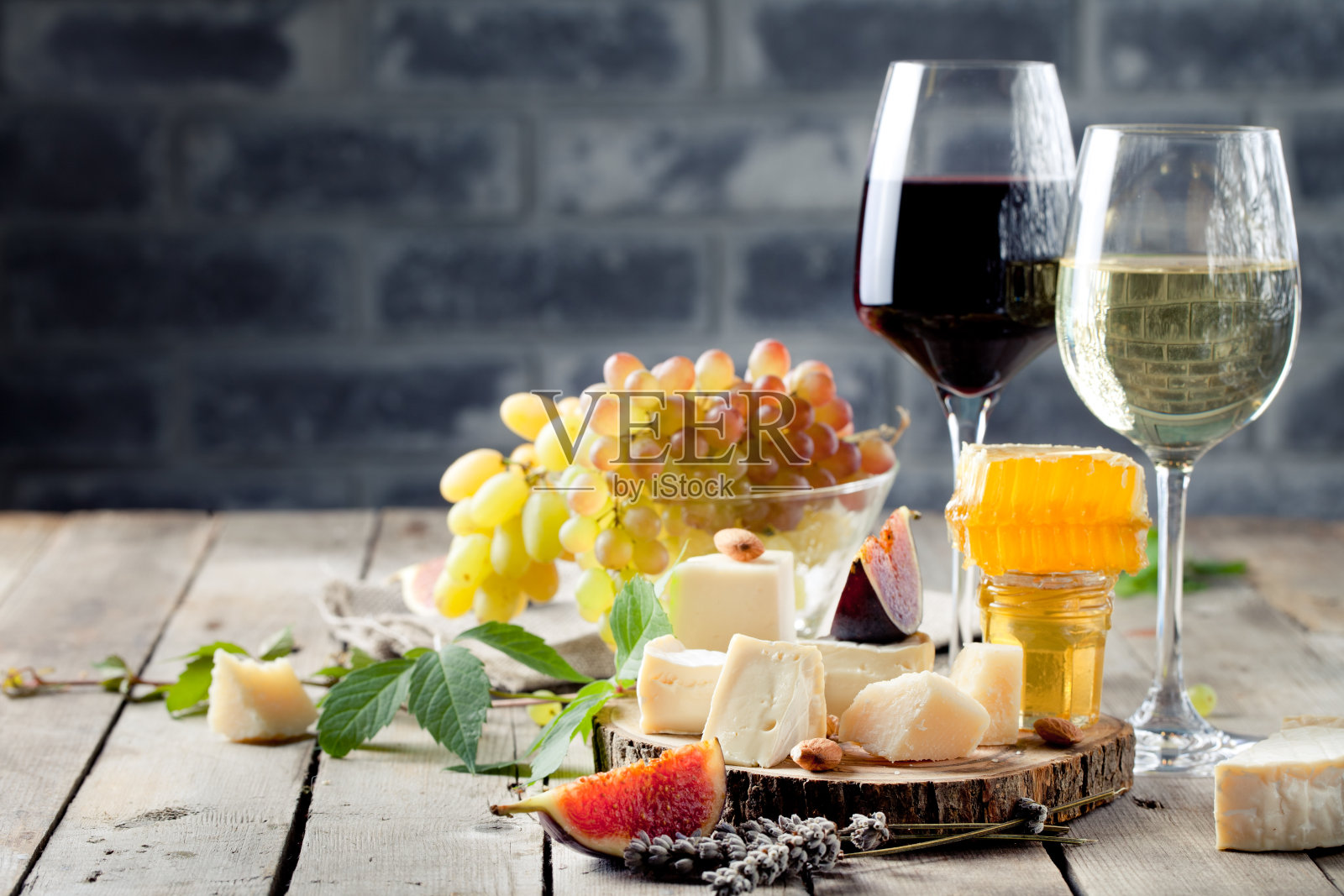 葡萄，奶酪，无花果和蜂蜜配一杯酒。照片摄影图片