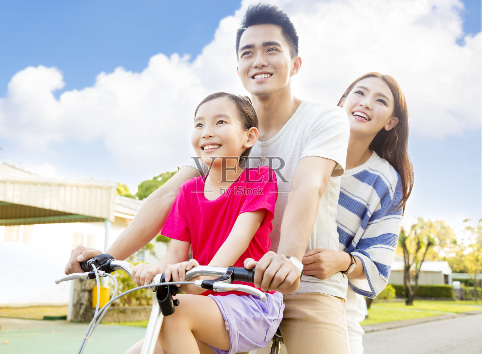快乐的亚洲家庭在公园里玩自行车照片摄影图片