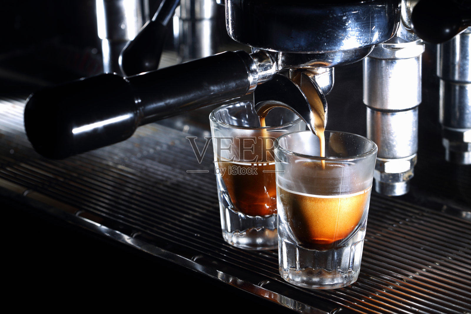 煮咖啡的浓缩咖啡机。咖啡倒入小酒杯照片摄影图片