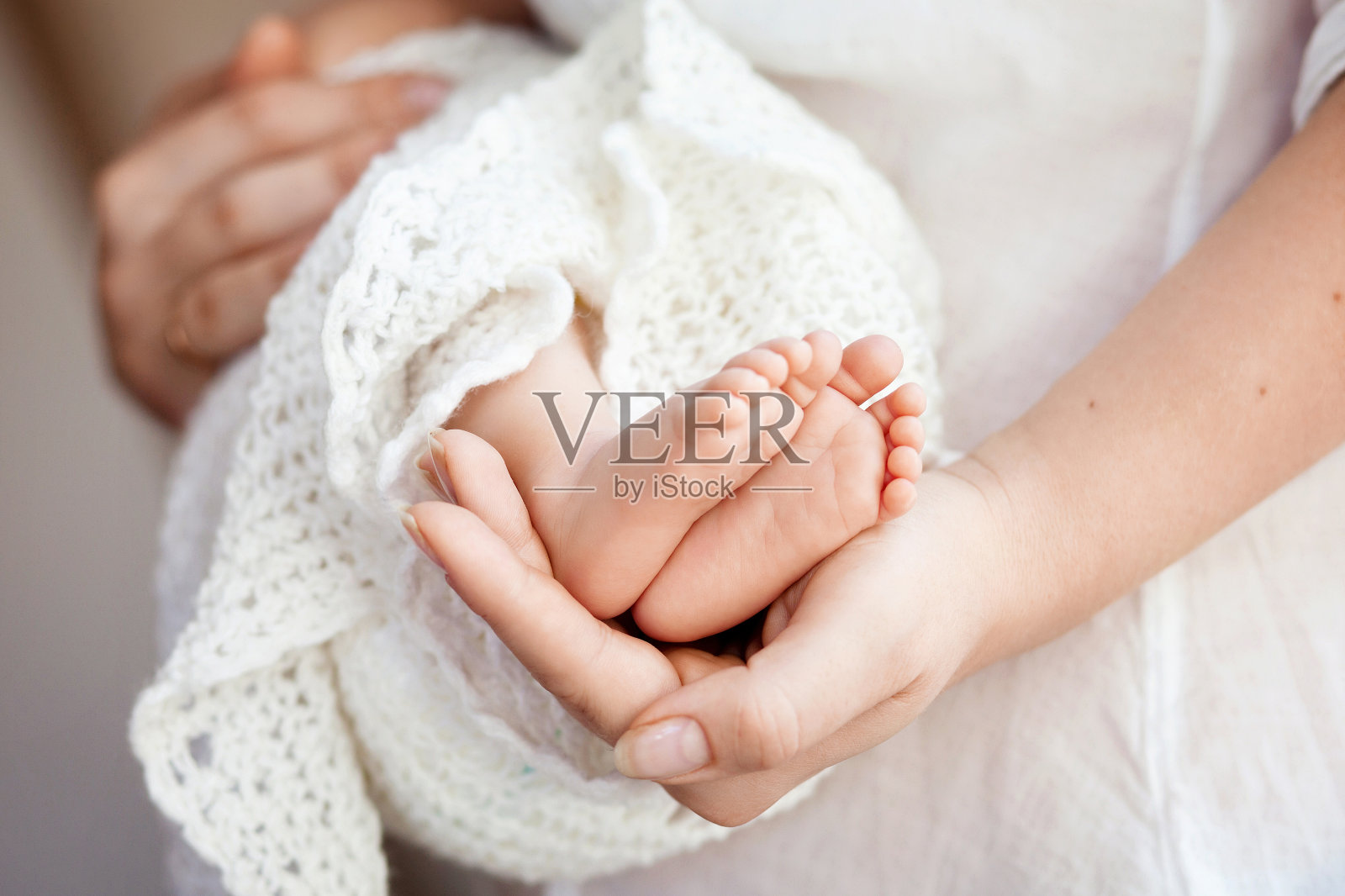婴儿的脚在妈妈的手里。妈妈和孩子。照片摄影图片