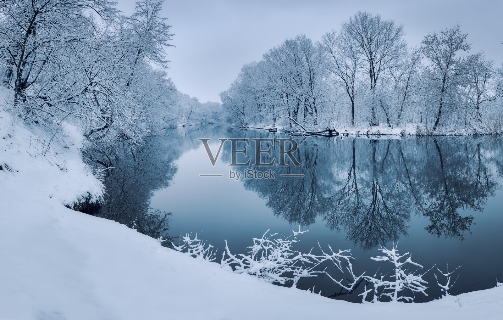 色彩斑斓的风景，白雪皑皑的树木，美丽的河流在日落照片摄影图片