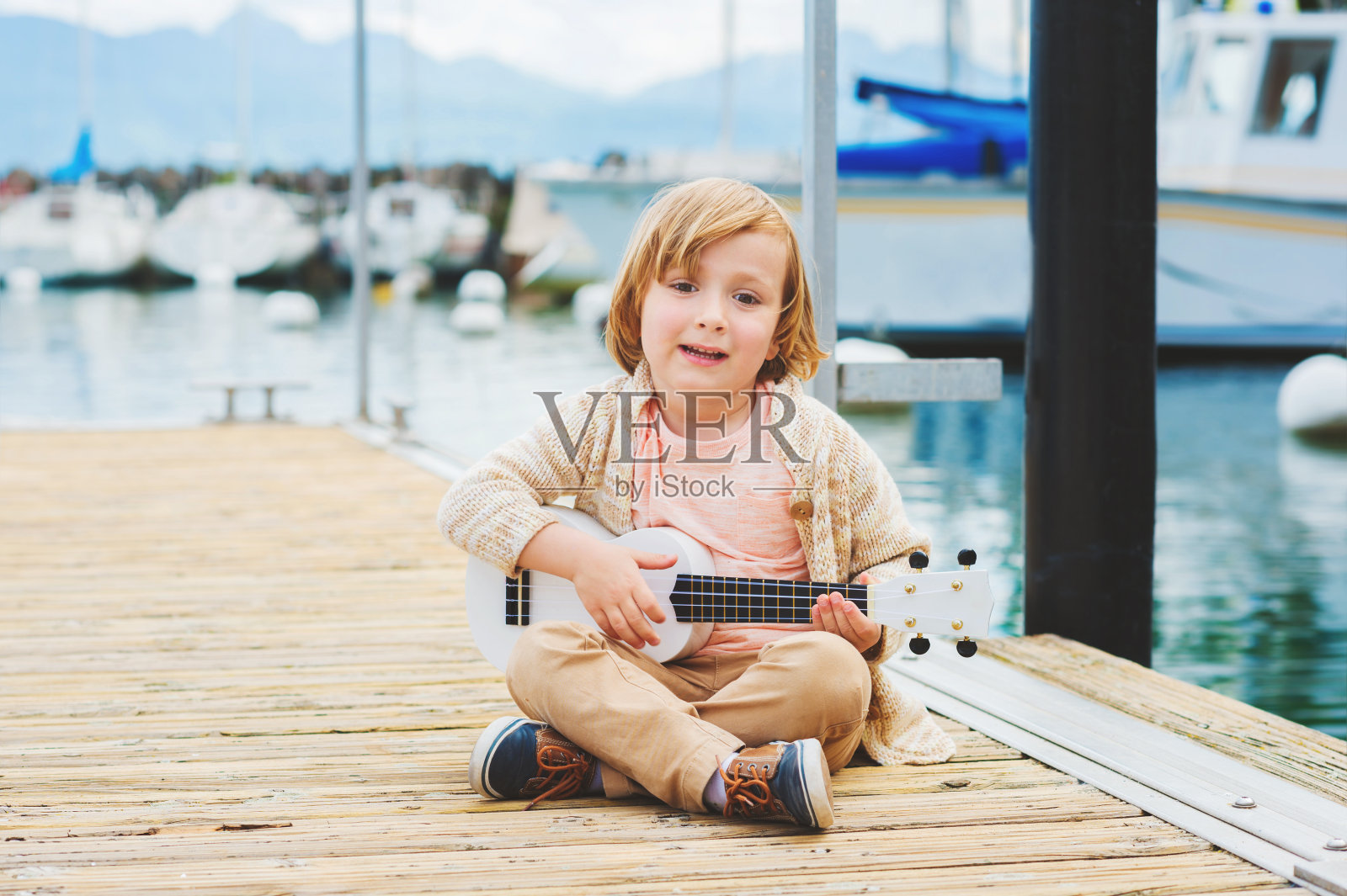 快乐的小男孩弹吉他照片摄影图片