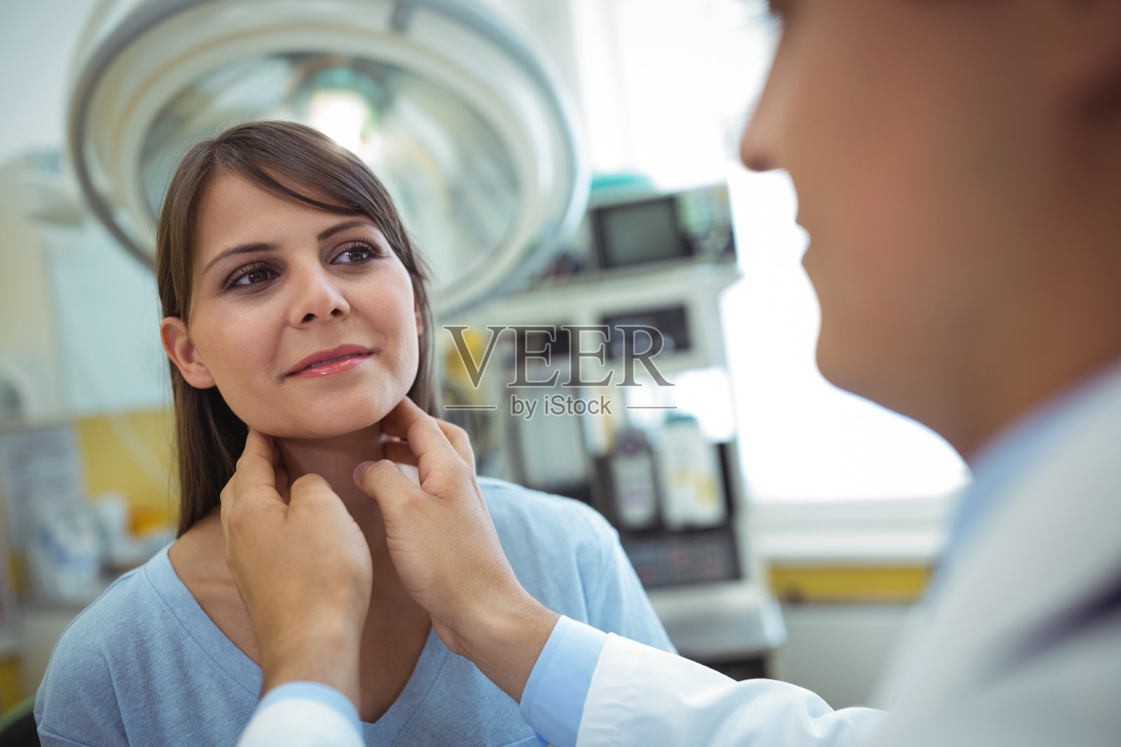 医生检查一位女性病人的颈部照片摄影图片