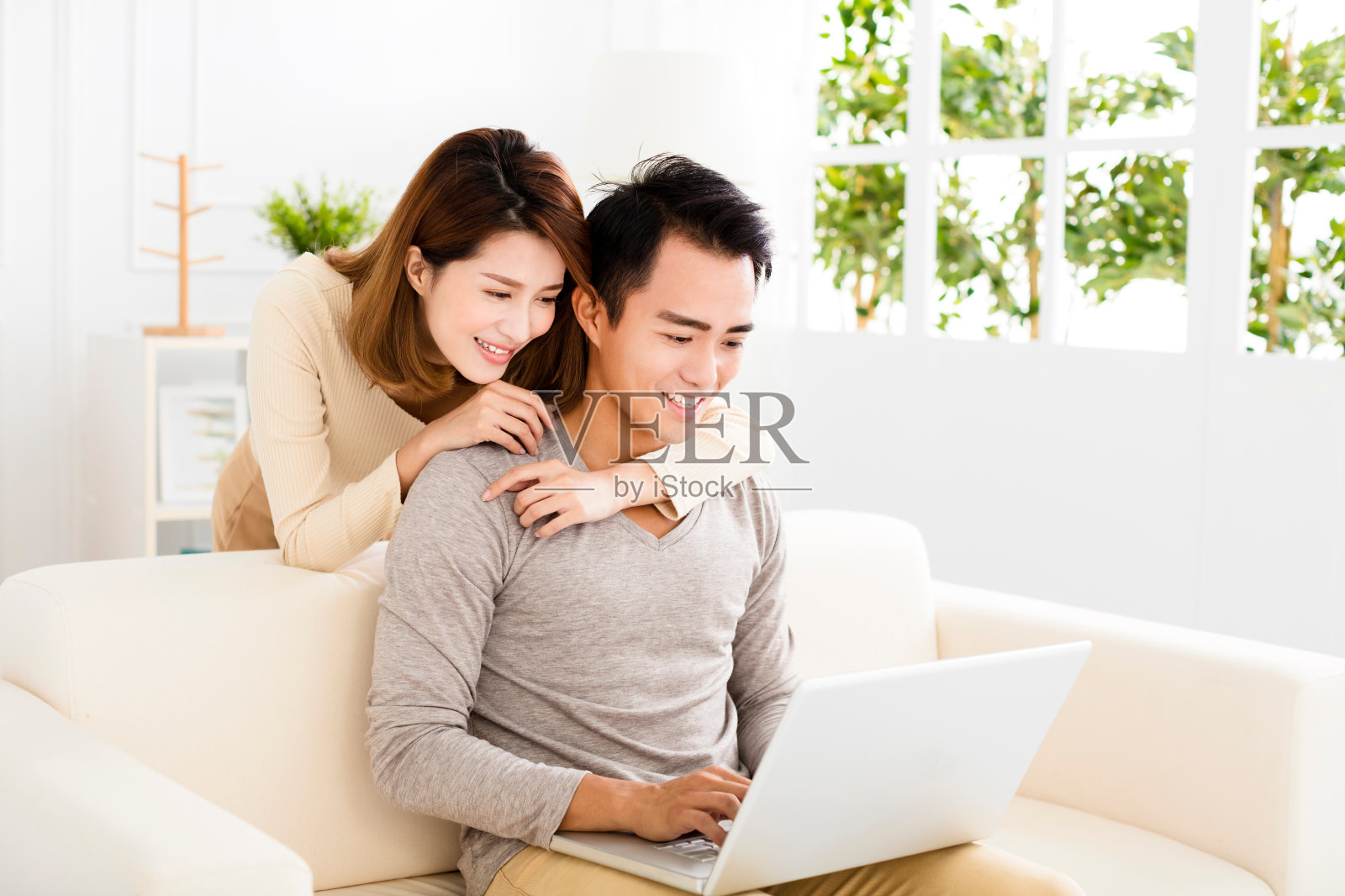 幸福的年轻夫妇在沙发上使用笔记本电脑照片摄影图片