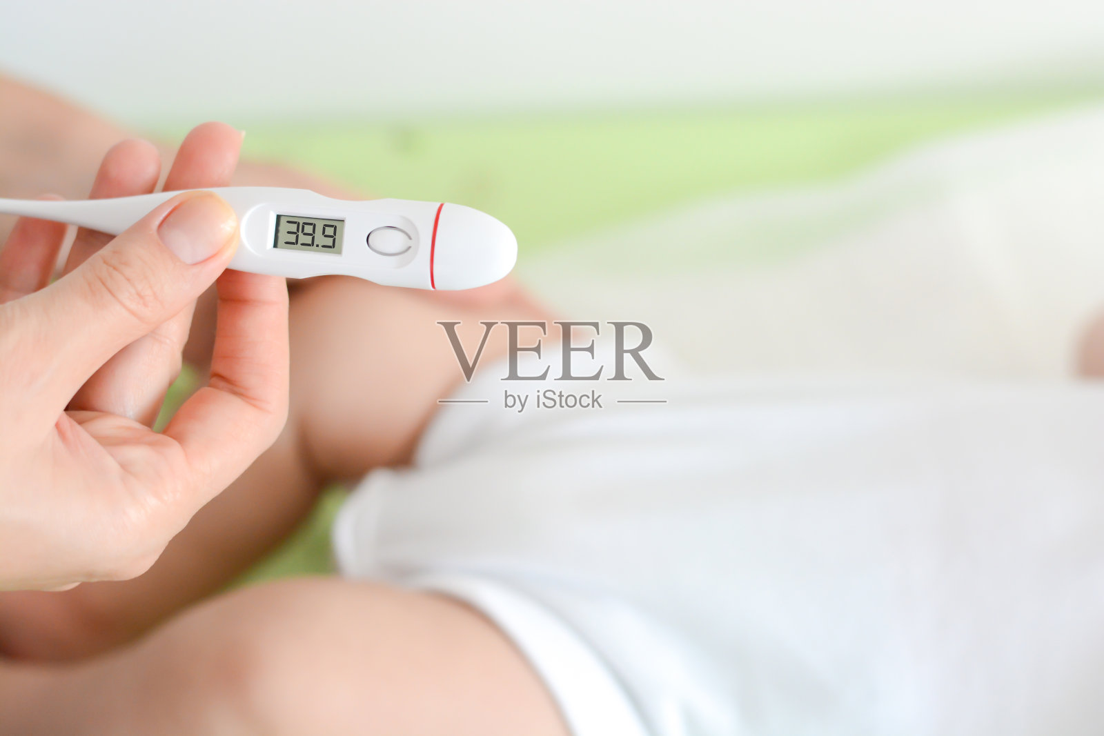 用体温计检查婴儿的体温，显示高烧照片摄影图片
