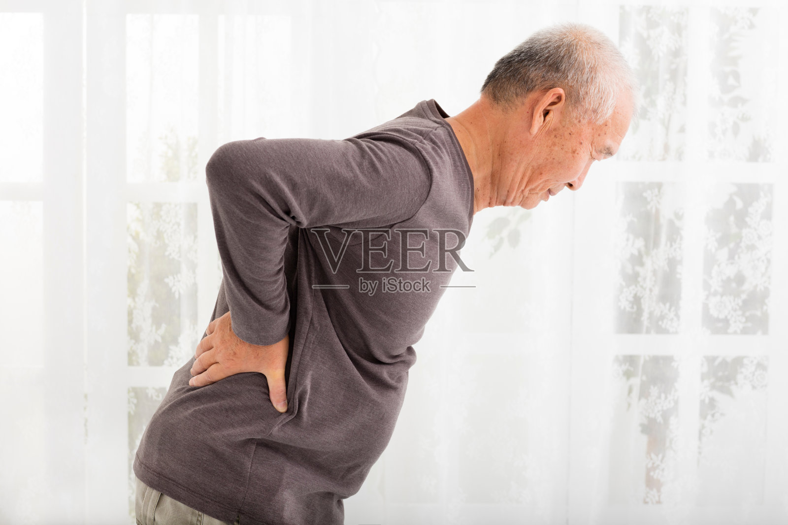 一位背部疼痛的资深男士照片摄影图片
