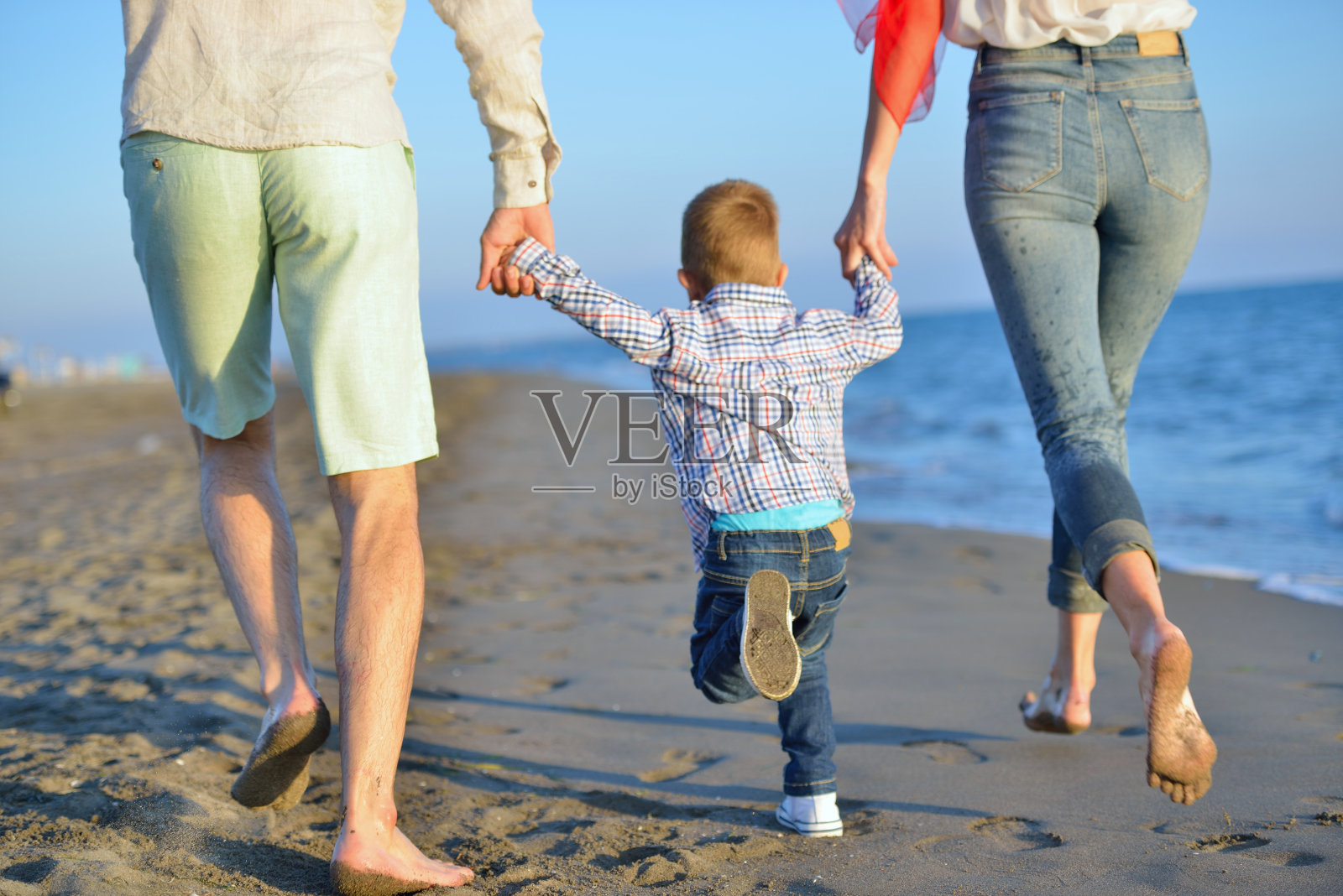 快乐的年轻家庭在海滩上玩得开心照片摄影图片