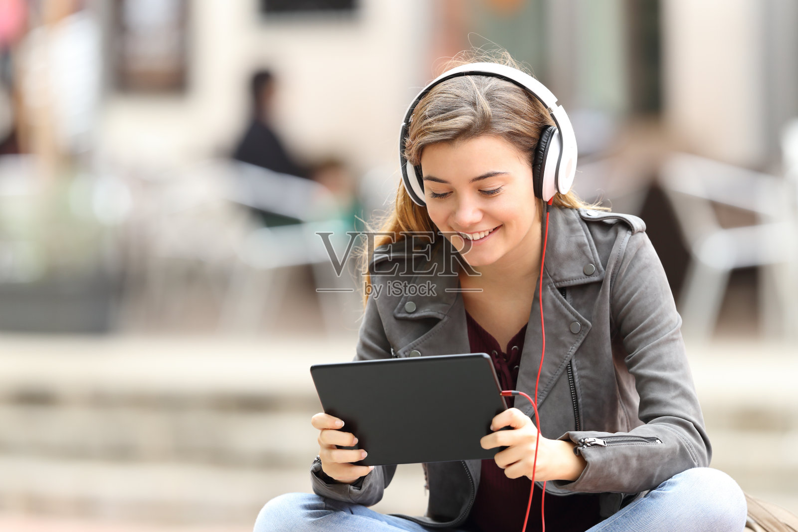 一个女孩带着平板电脑和耳机在网上学习照片摄影图片