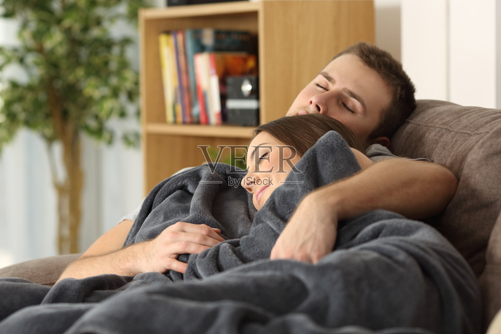 一对情侣一起睡在家里的沙发上照片摄影图片