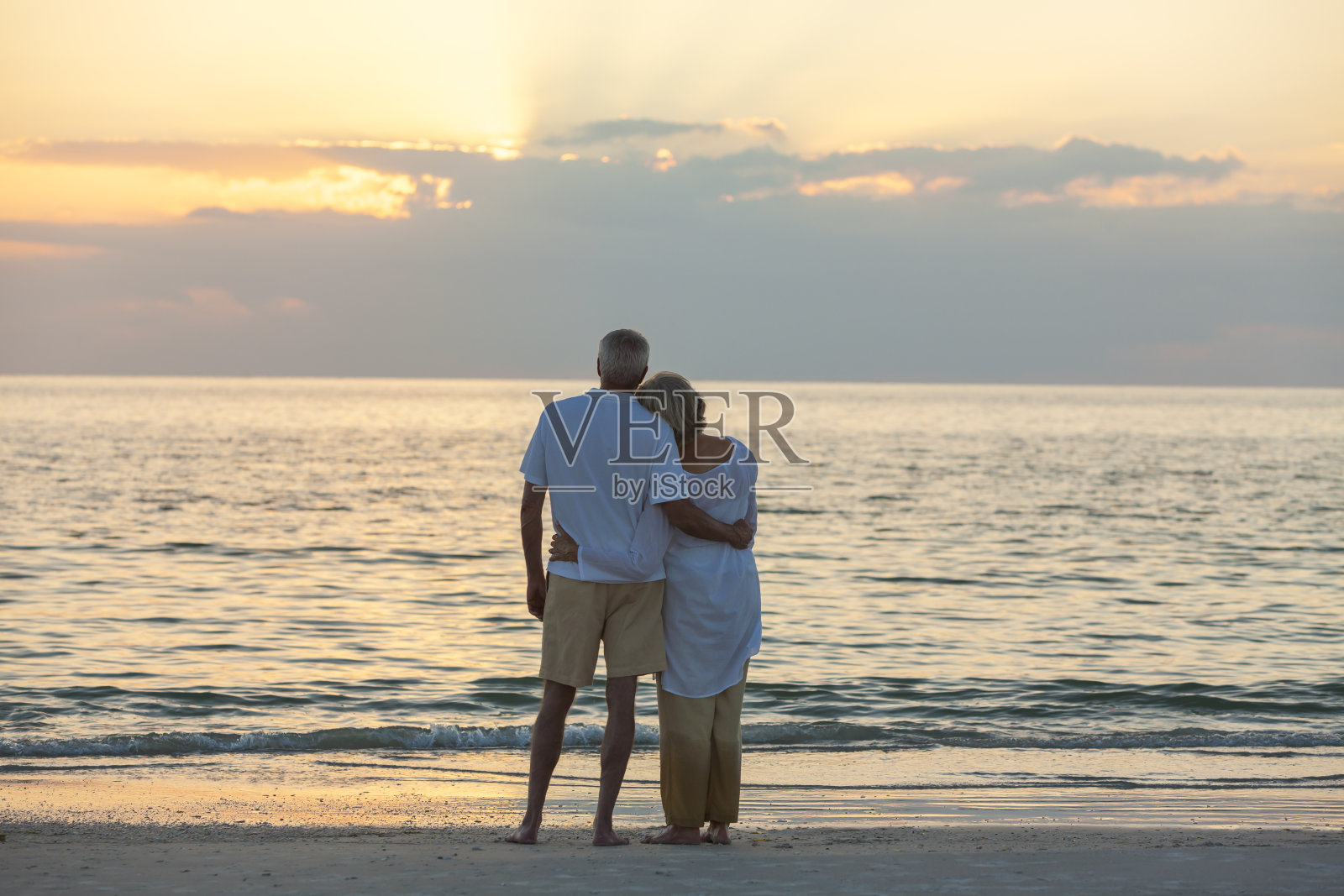一对老年夫妇在日落热带海滩照片摄影图片