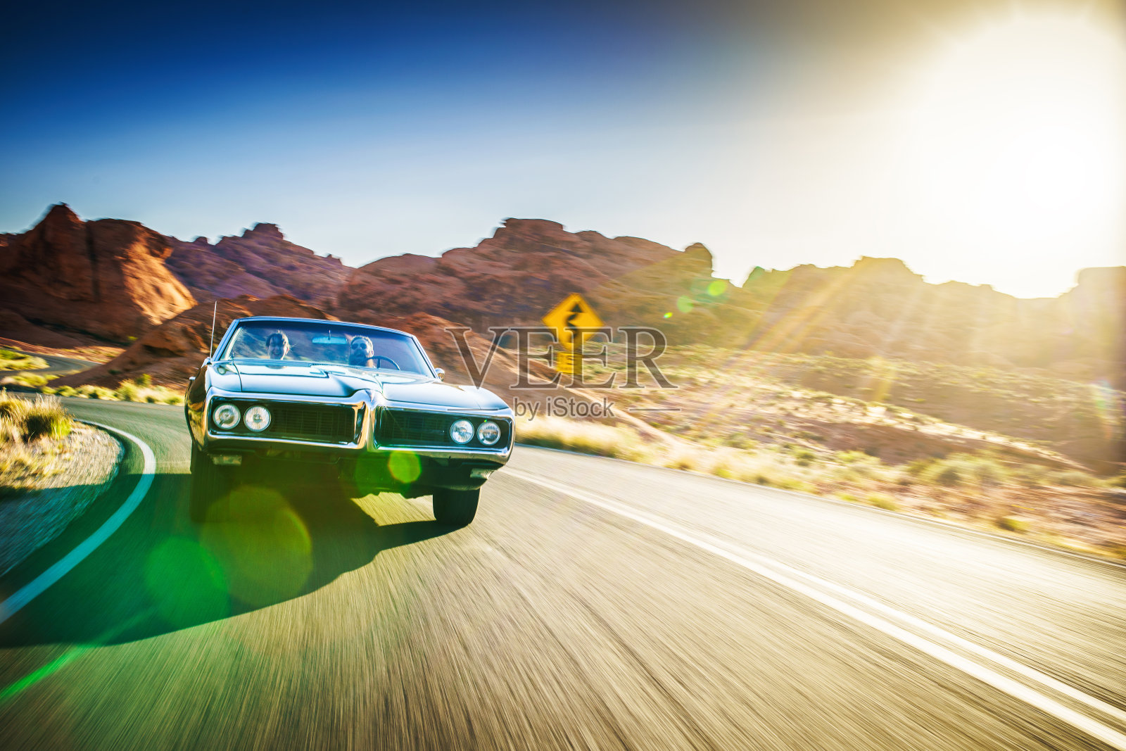 一对情侣开着一辆很酷的老爷车穿越沙漠照片摄影图片