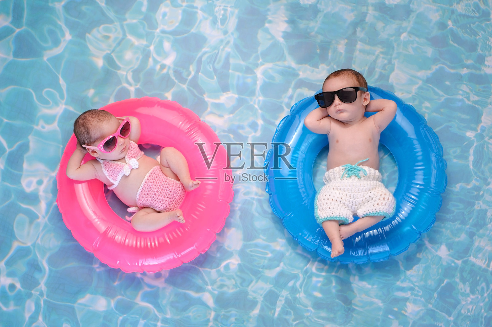 双胞胎男孩和女孩漂浮在游泳环上照片摄影图片