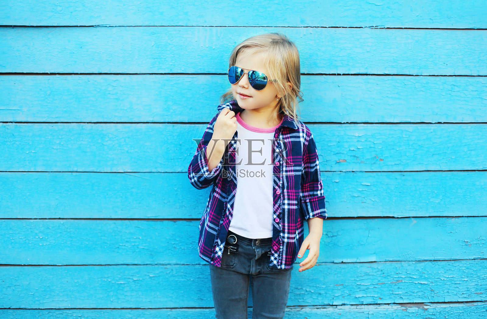 城市里的时尚小子，戴着蓝色太阳镜的时尚小子照片摄影图片