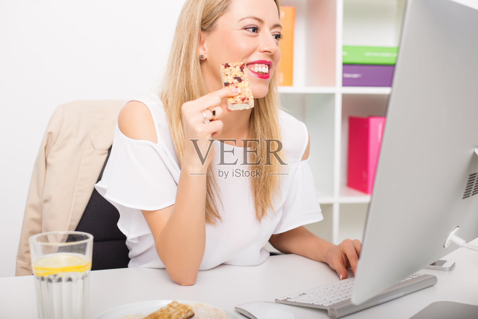 工作时吃燕麦棒的女人照片摄影图片
