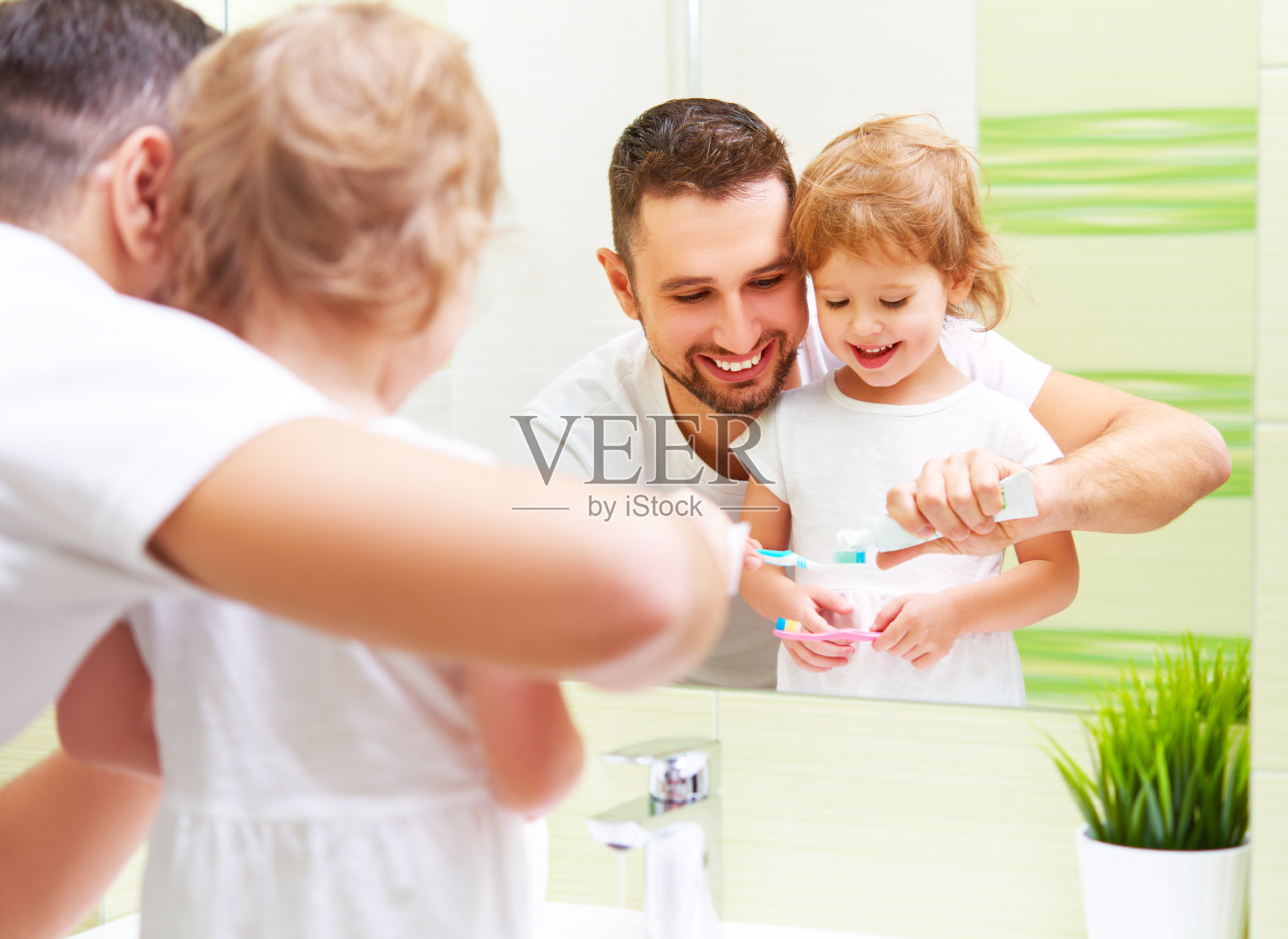 快乐的家庭，父亲和女儿在刷牙照片摄影图片