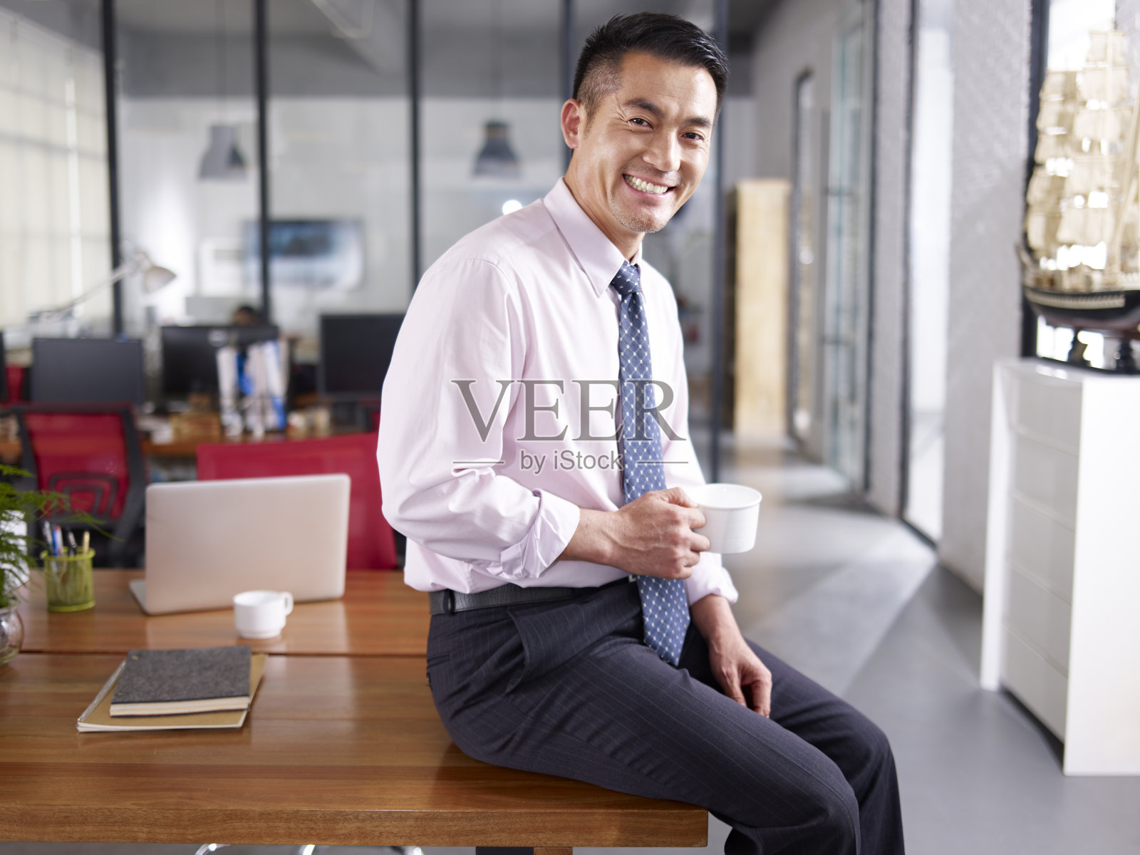一个快乐的亚洲商业主管在办公室的肖像照片摄影图片