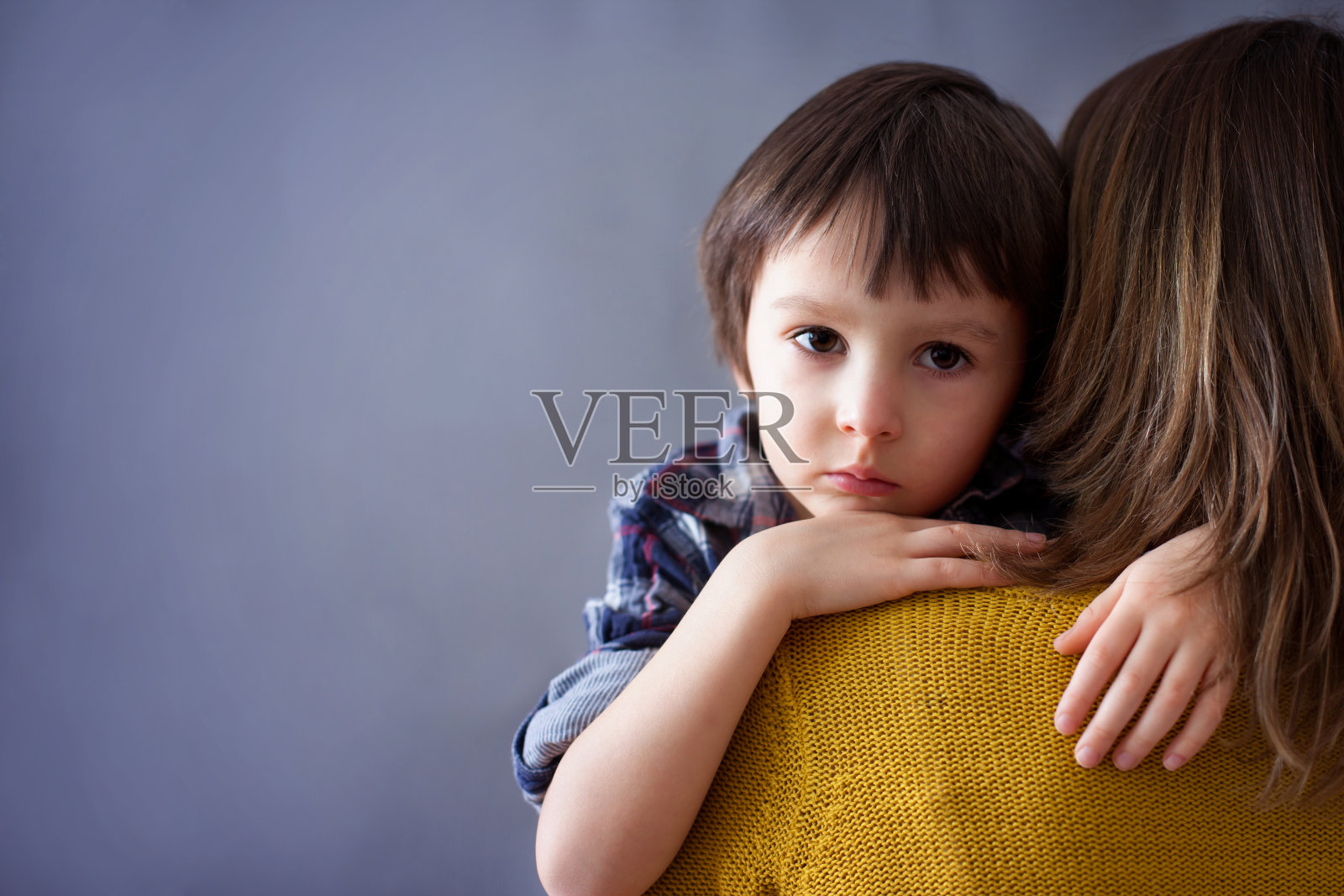 可怜的小男孩，在家里拥抱他的妈妈照片摄影图片