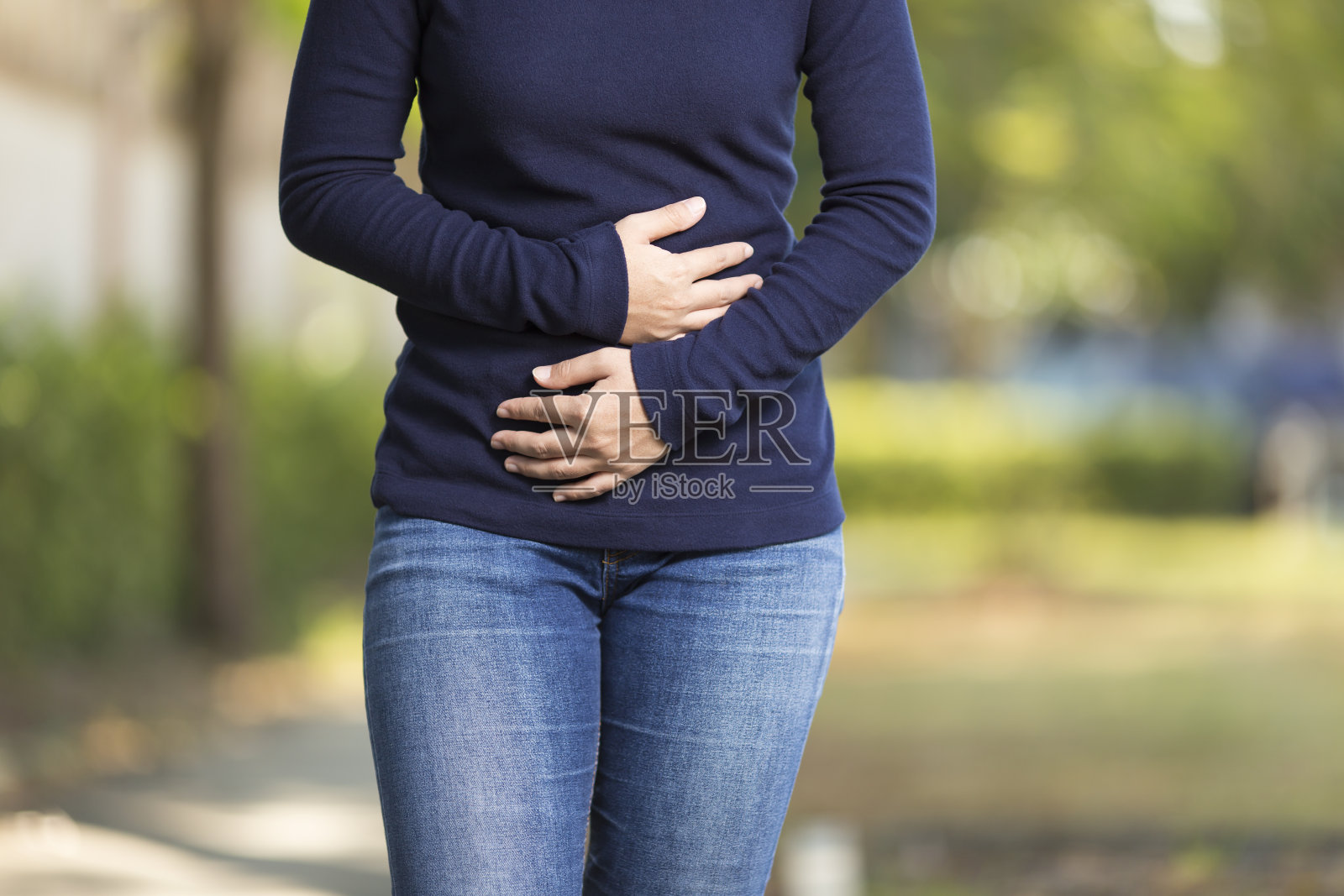 女人在公园胃痛照片摄影图片