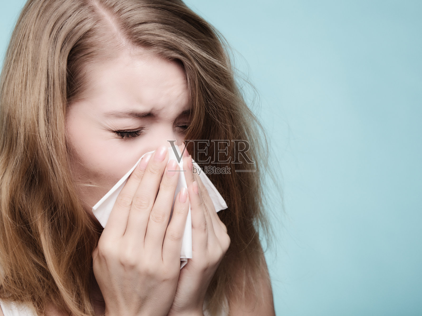 流感过敏。生病的女孩用纸巾打喷嚏。健康照片摄影图片