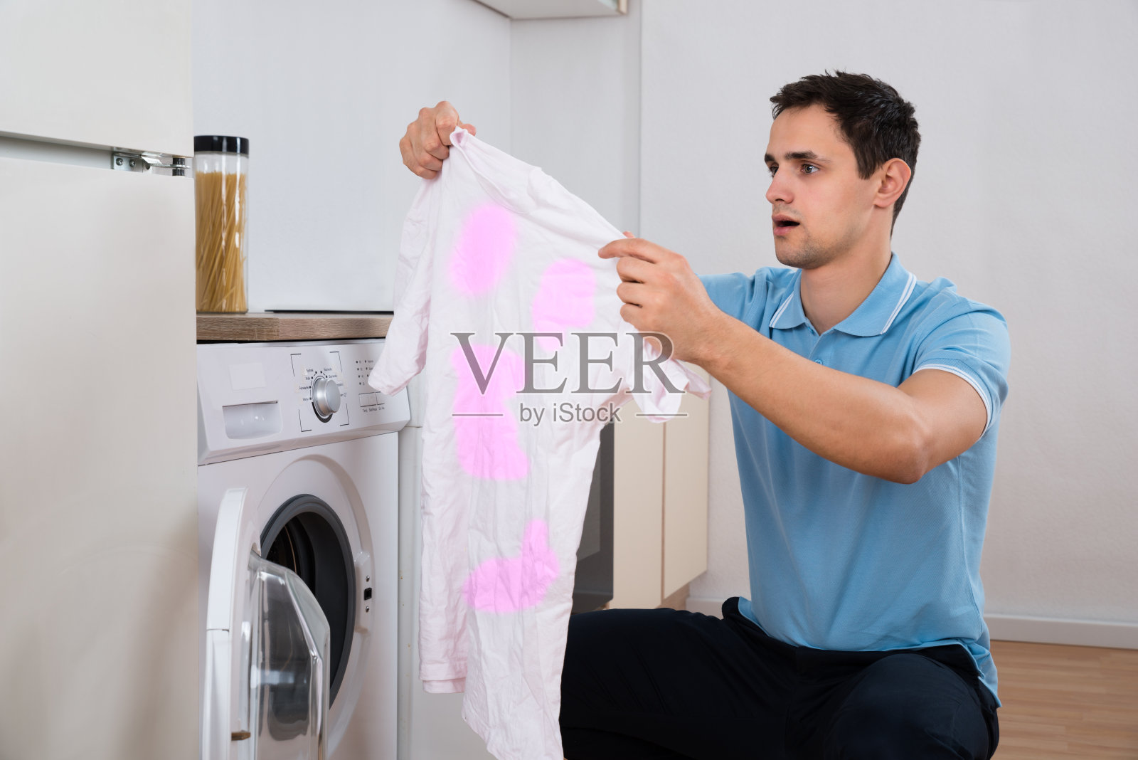 被洗衣机洗脏t恤的震惊男子照片摄影图片