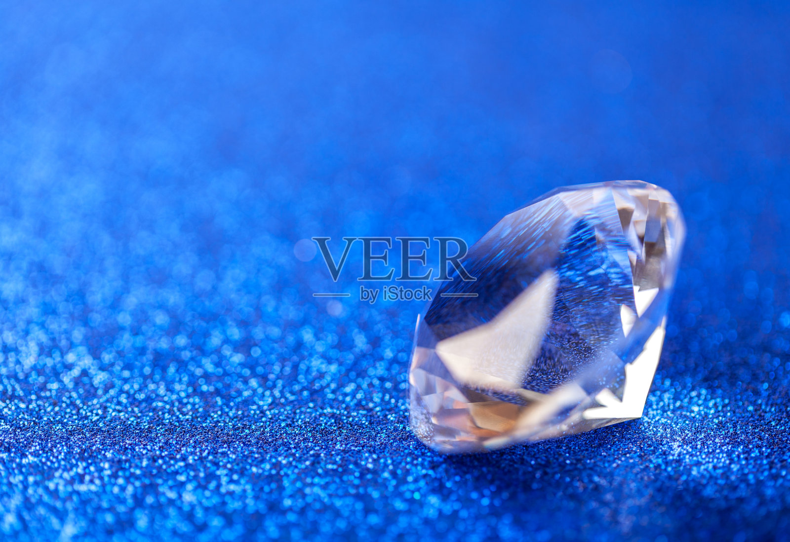 大纯钻石在蓝色亮片背景，宏观。才华横溢的特写镜头照片摄影图片