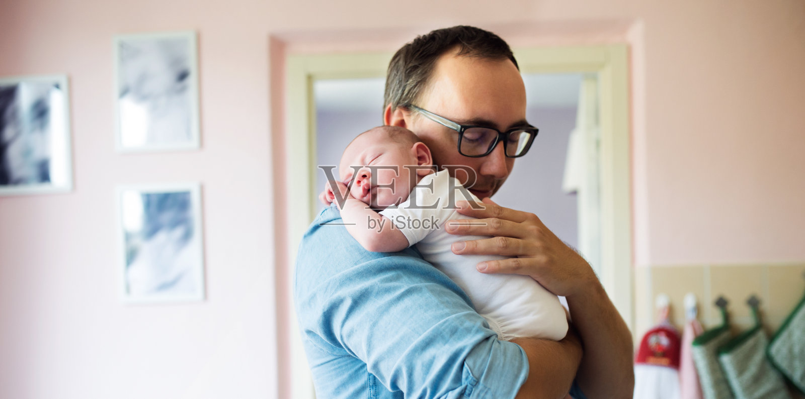 年轻的父亲抱着刚出生的儿子照片摄影图片