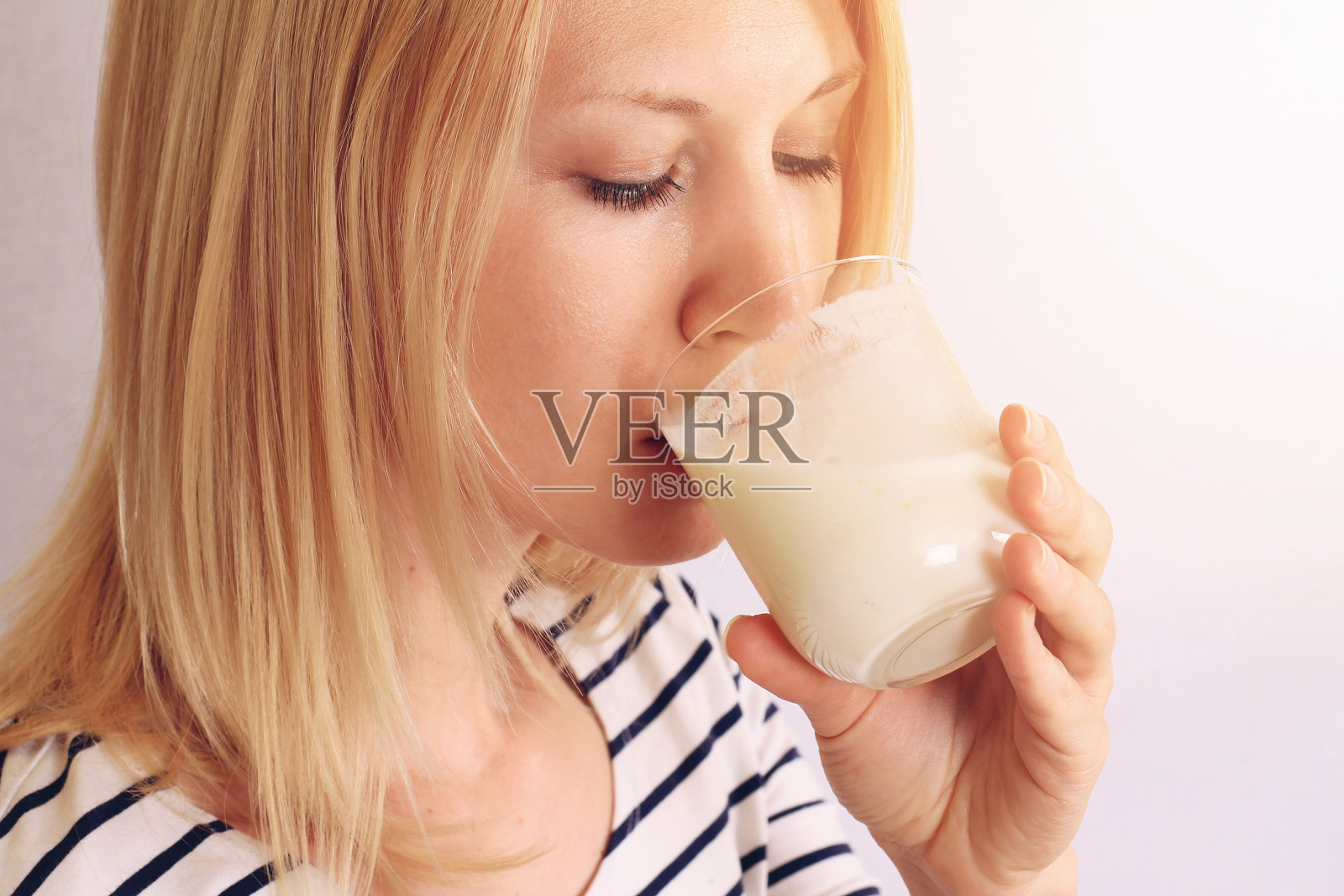 喝牛奶/酸奶的女人。乳制品的概念照片摄影图片