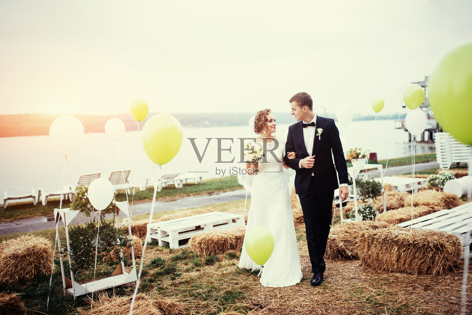 美丽年轻的新婚夫妇亲吻，金发新娘与鲜花照片摄影图片