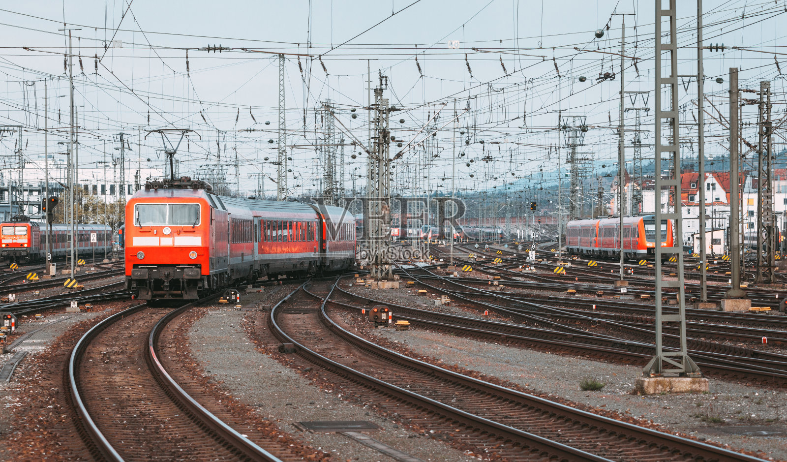 日落时分，有现代化的红色通勤列车的火车站照片摄影图片