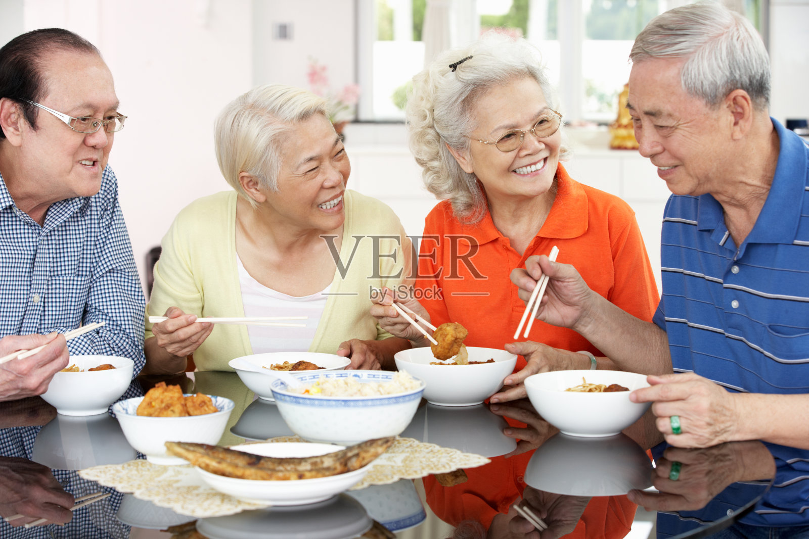 一群老年人在家用筷子吃亚洲食物照片摄影图片