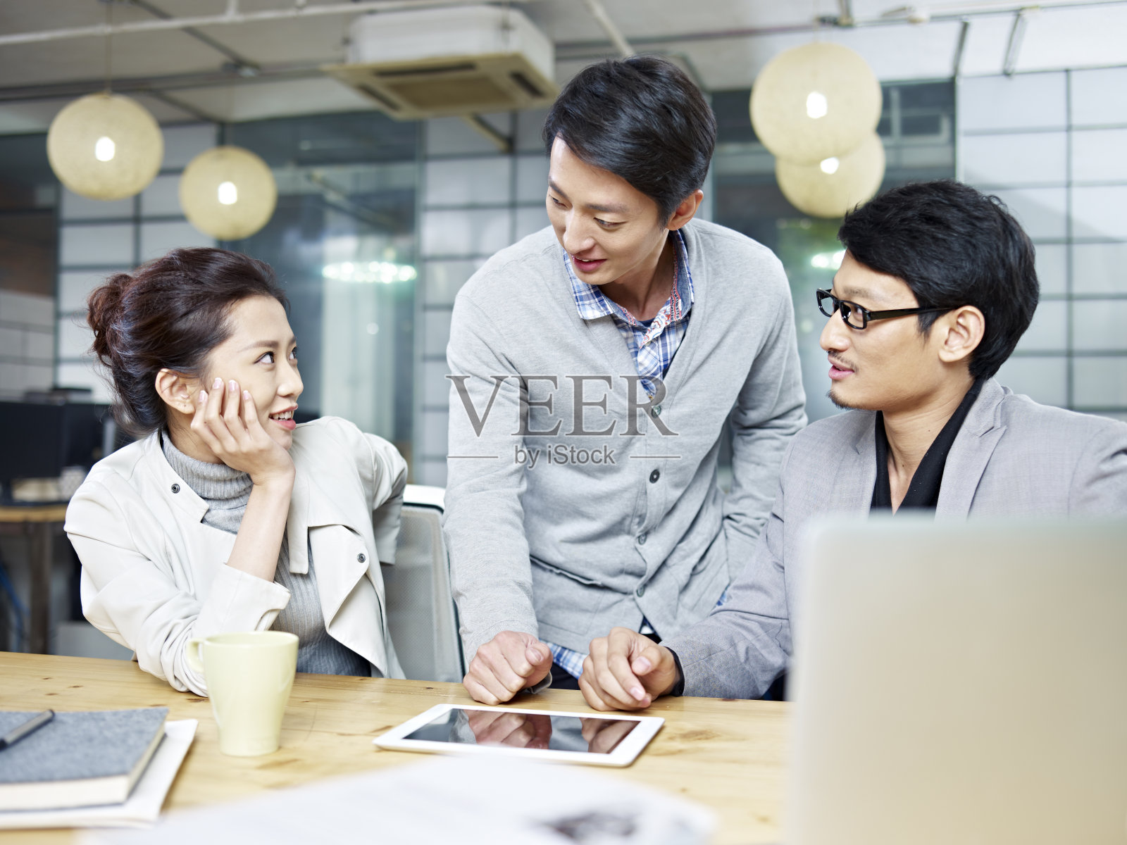 年轻的亚洲企业家在办公室里讨论生意照片摄影图片