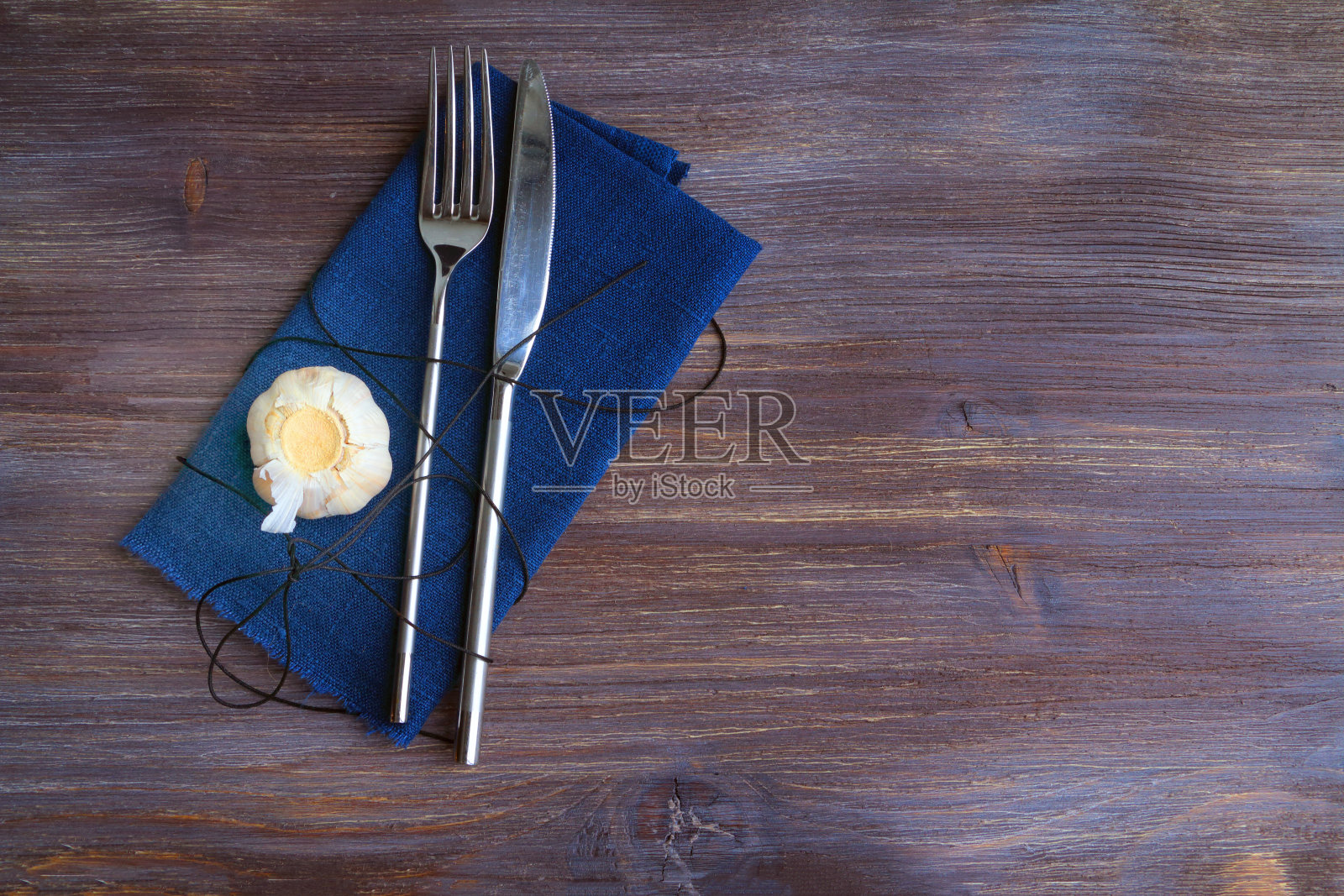 蓝色餐巾上放着简单的钢制餐具照片摄影图片