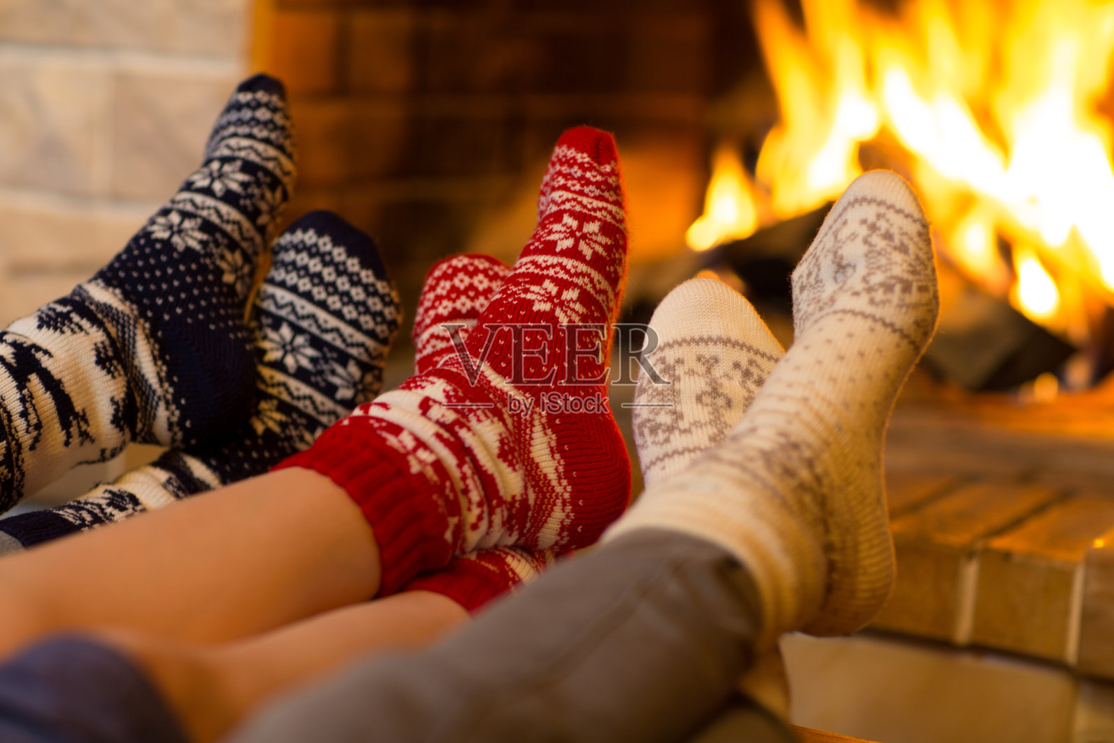 在冬天或圣诞节的时候，在壁炉旁边的袜子里的家人照片摄影图片
