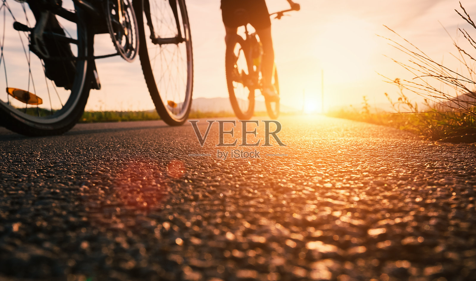 自行车车轮靠近的图像上的沥青日落道路照片摄影图片
