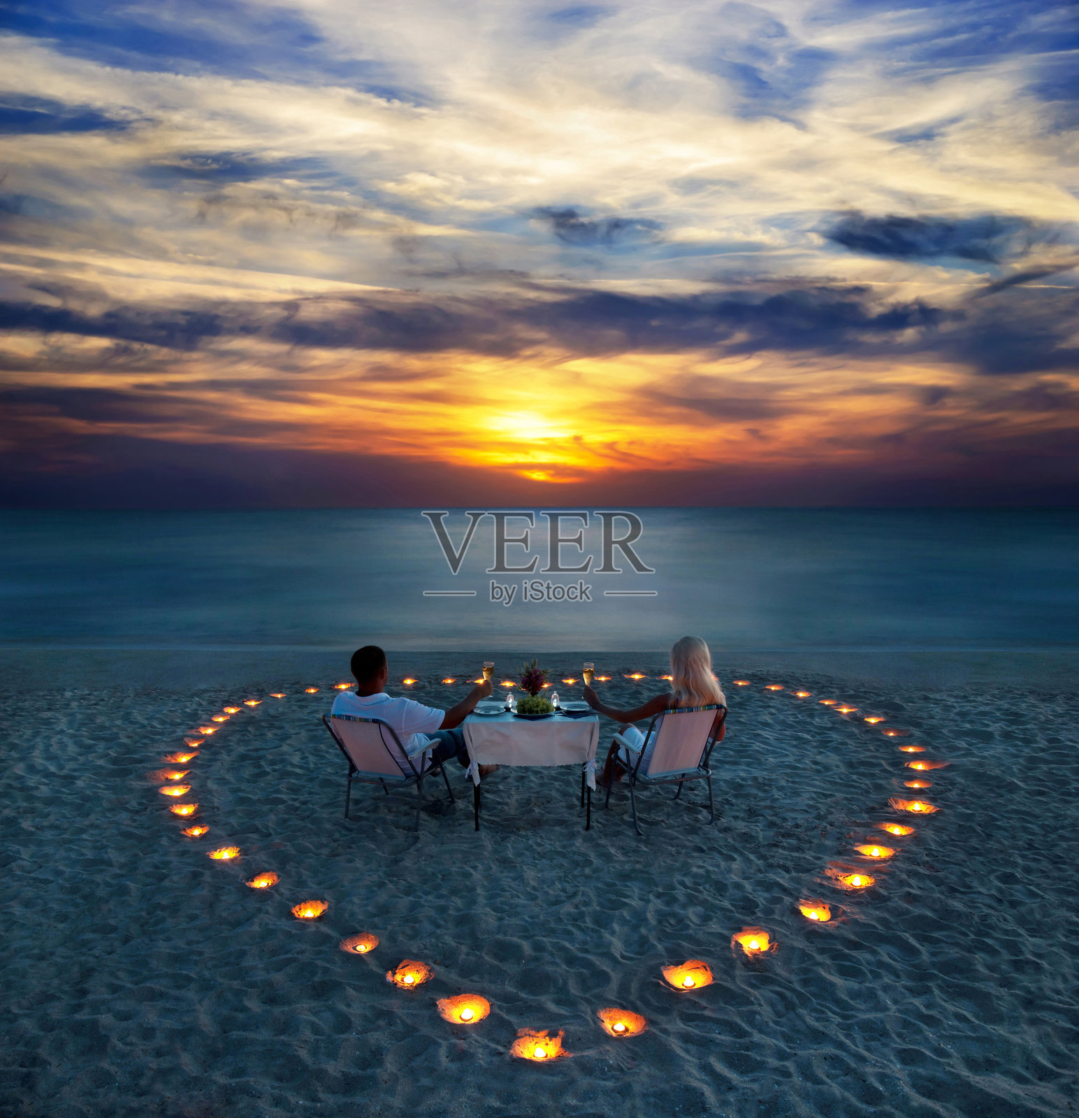 一对年轻夫妇在海滩上共享浪漫晚餐照片摄影图片