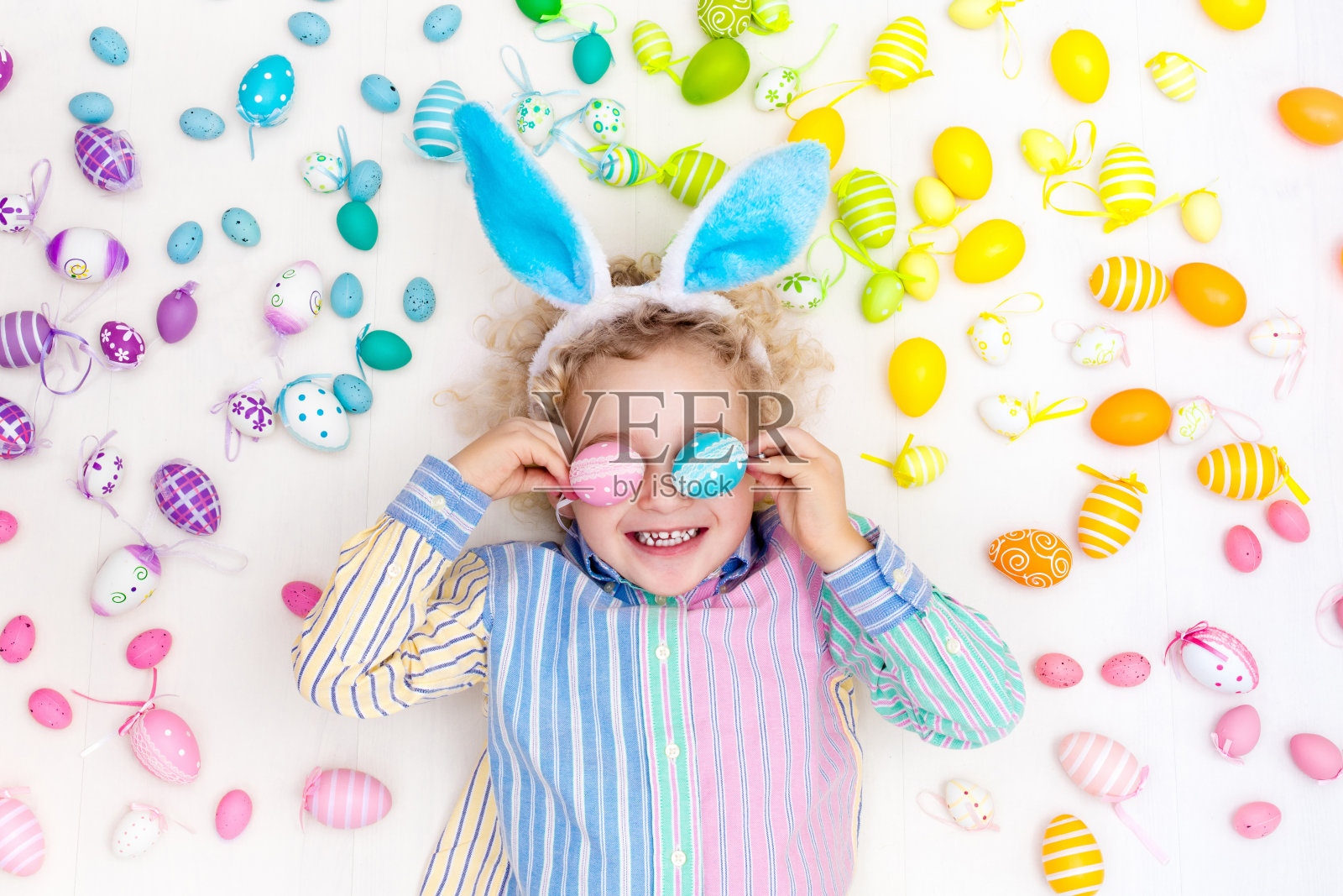 寻找复活节彩蛋的孩子。柔和的彩虹鸡蛋。照片摄影图片